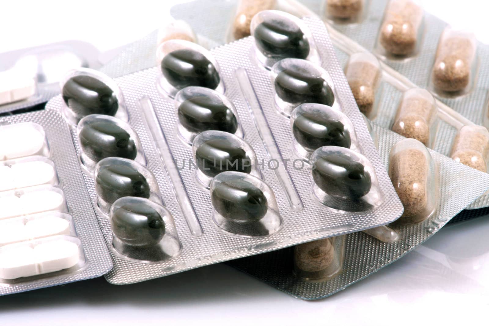 Pills of many shapes and colors grouped together