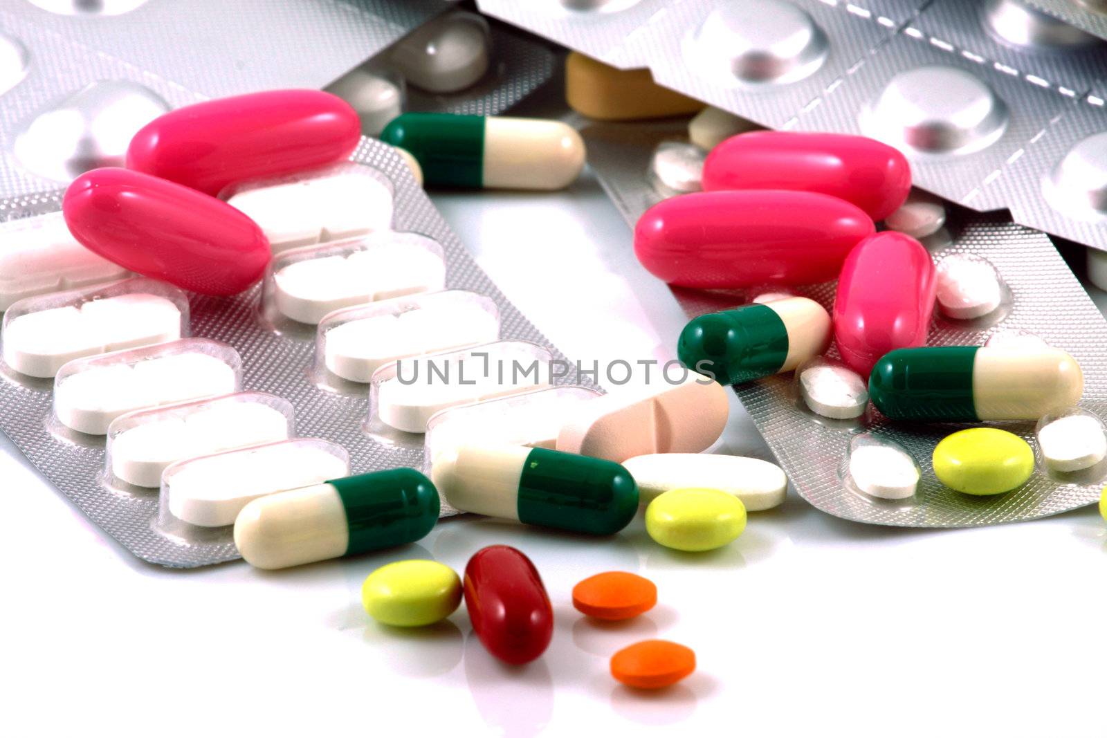 Pills of many shapes and colors grouped together