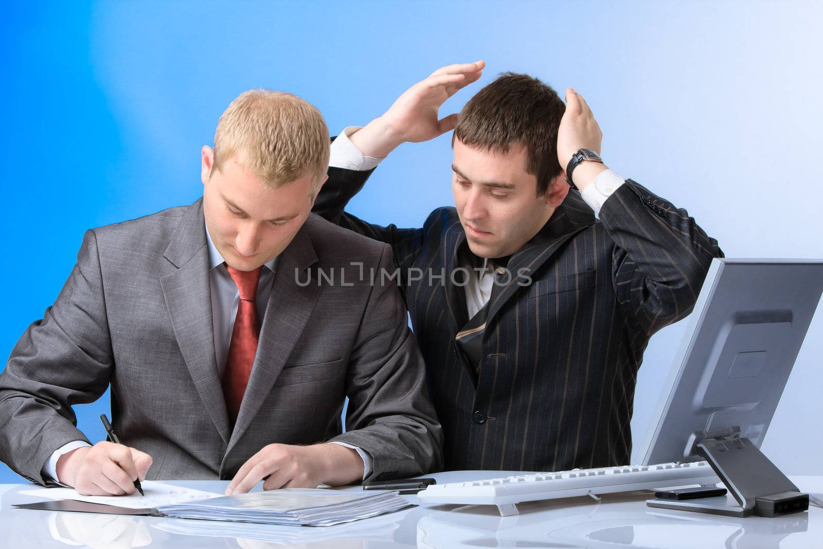 Two young attractive business men working in office