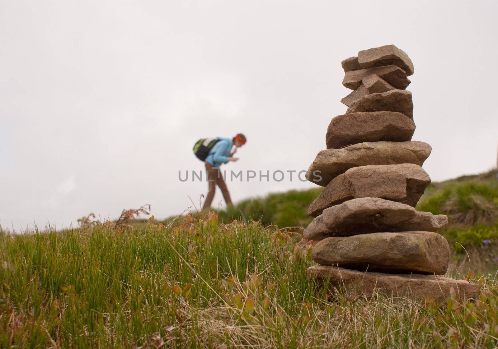 Stack of stones with teen girl tourist on background by AndreyKr