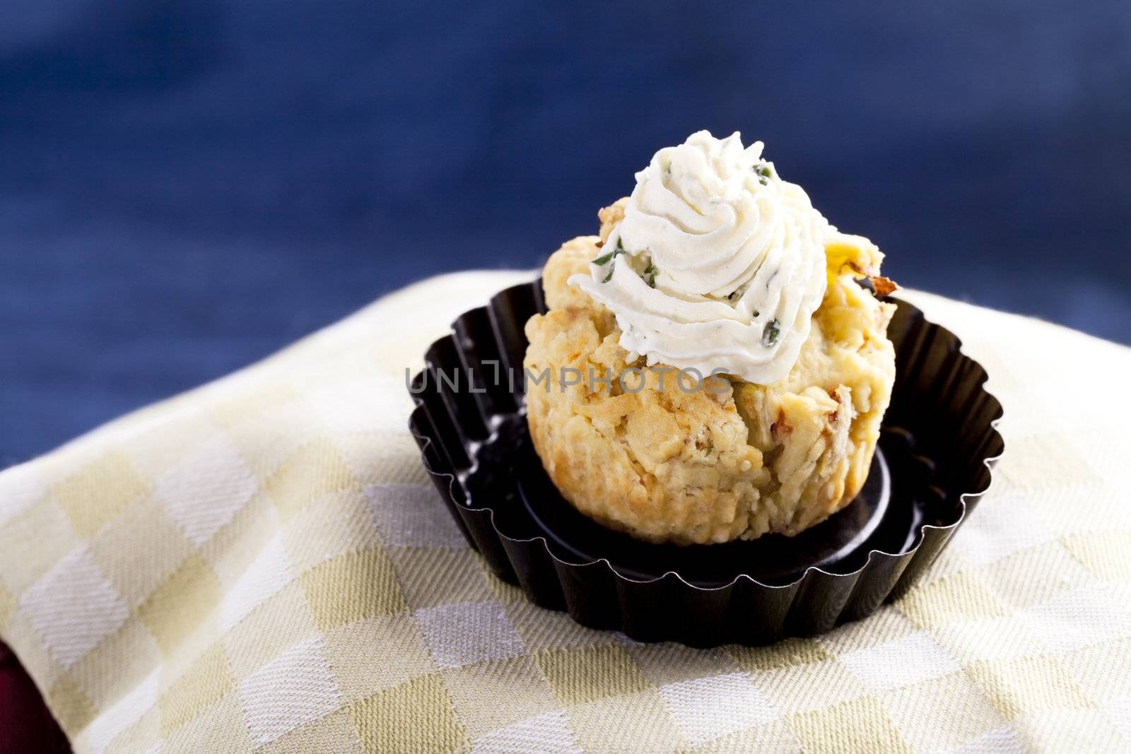 Dinner muffin topped with cream cheese.