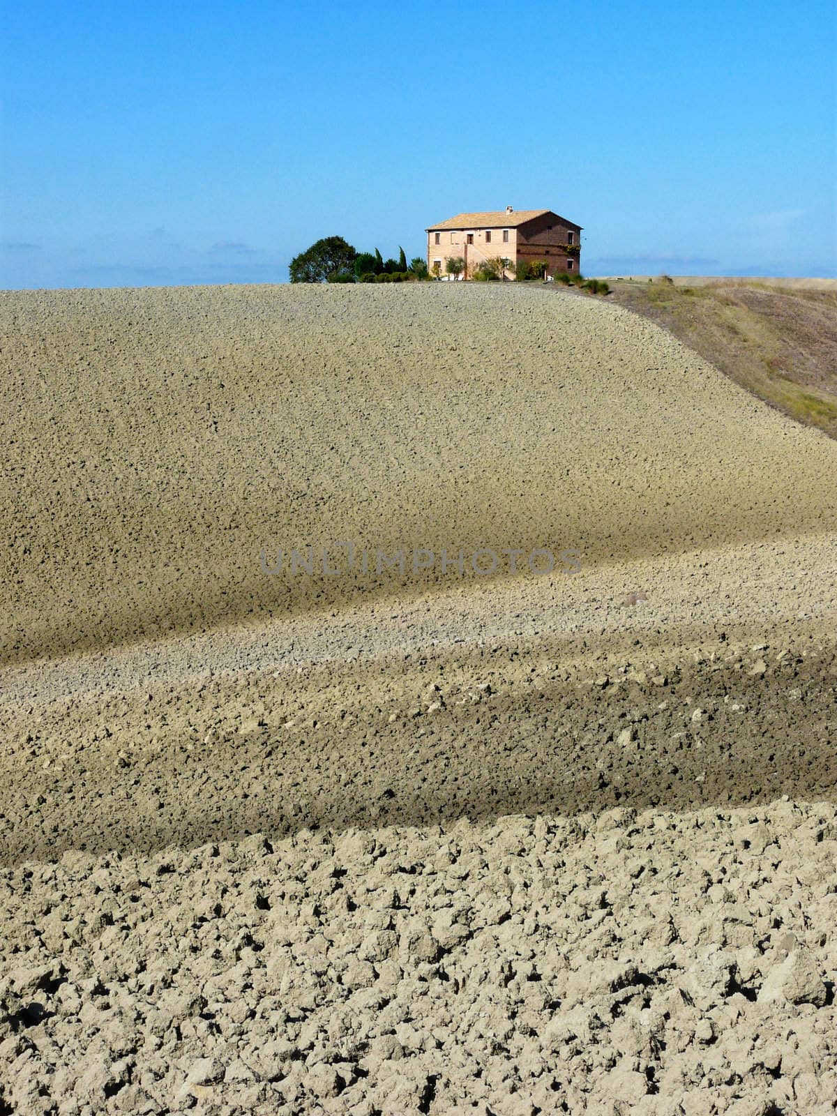 Typical Tuscan house with plowed fields in autumn near Pienza in the Val d�Orcia in Tuscany, Italy.