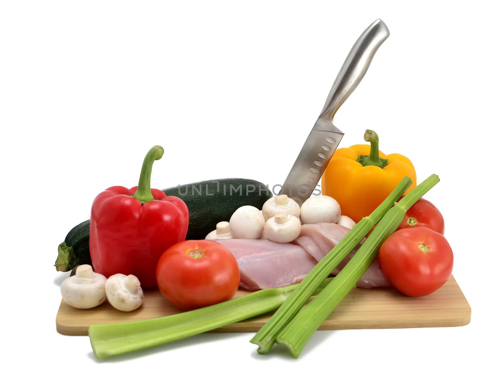 chicken, knife and vegetables on a cutting board, isolated on white