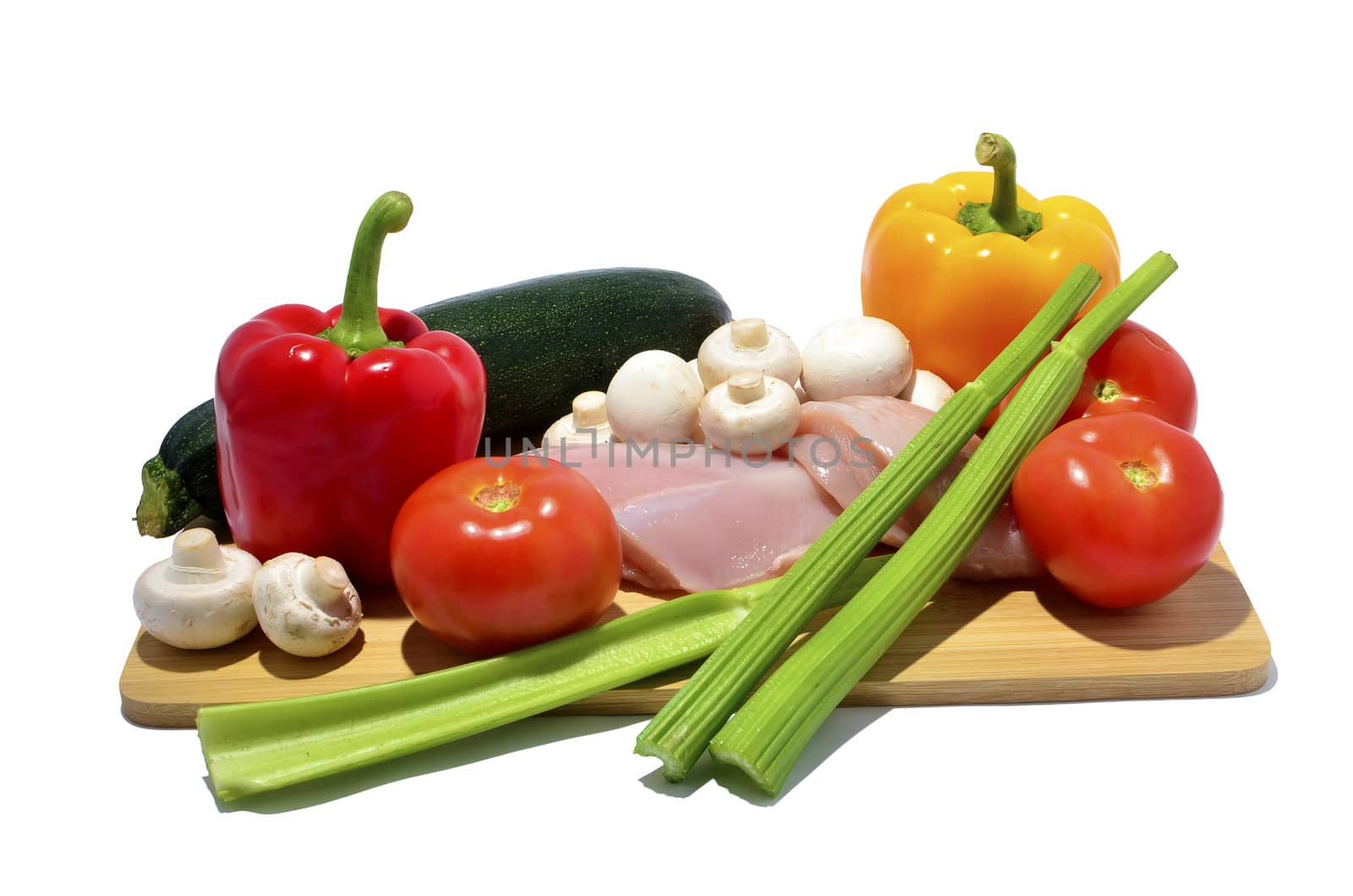 chicken, knife and vegetables on a cutting board, isolated on white