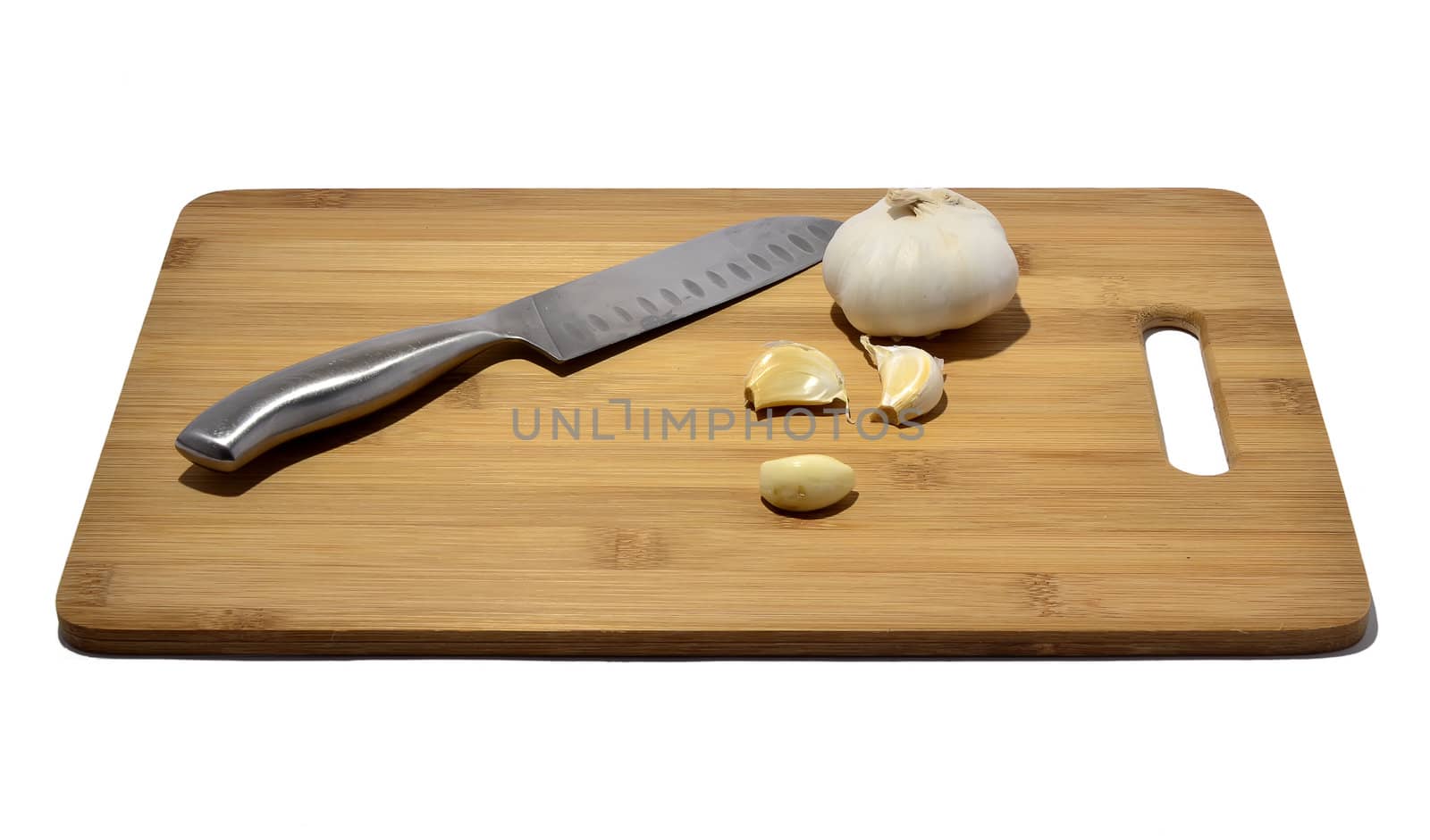 knife and garlic on a cutting board, isolated on white