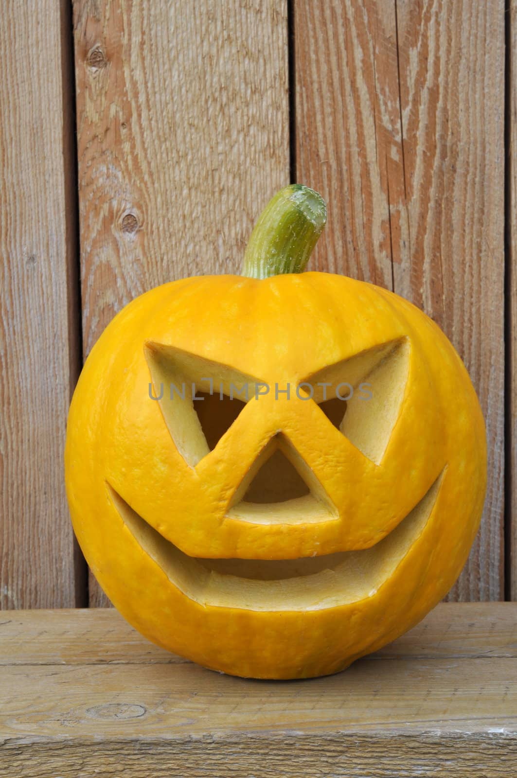 Symbol Halloween - a pumpkin � Lantern on a wooden bench against wooden boards..