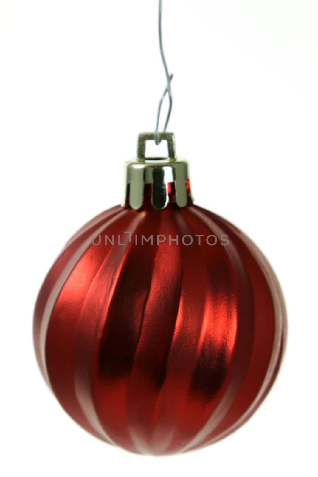 A single isolated red Christmas bauble hanging. (focus on middle of bauble)
