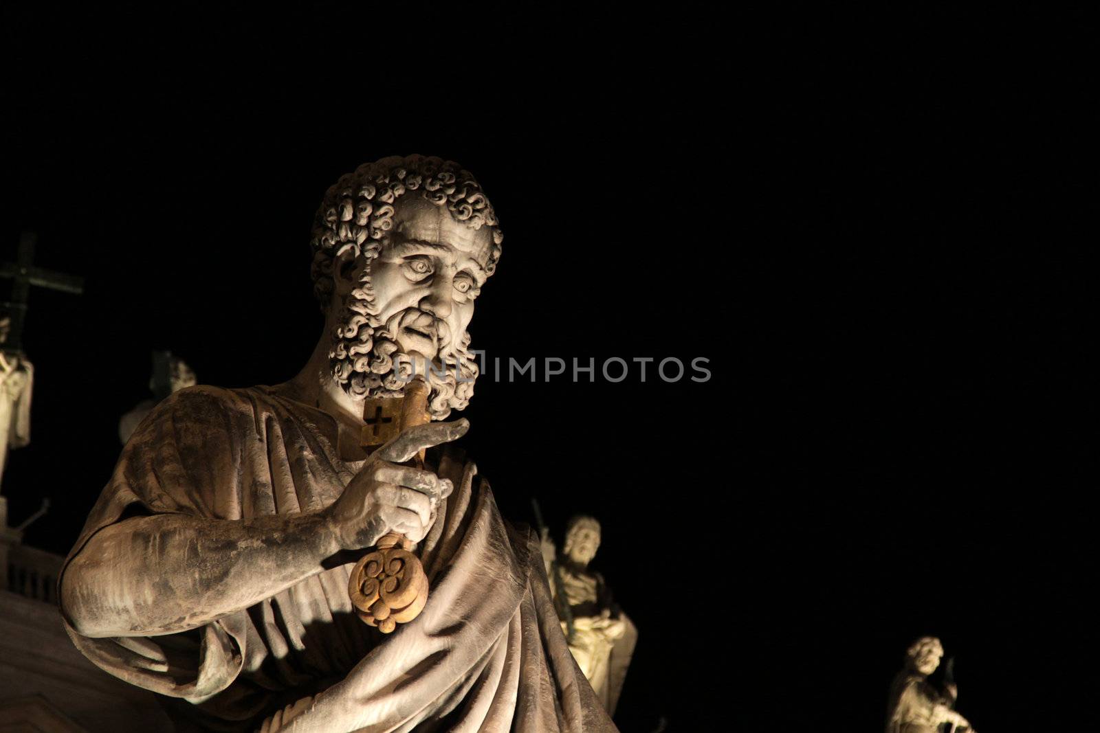 A statue of St. Peter outside St. Peter's Basilica, Vatican City, Rome.  Shot at night.
