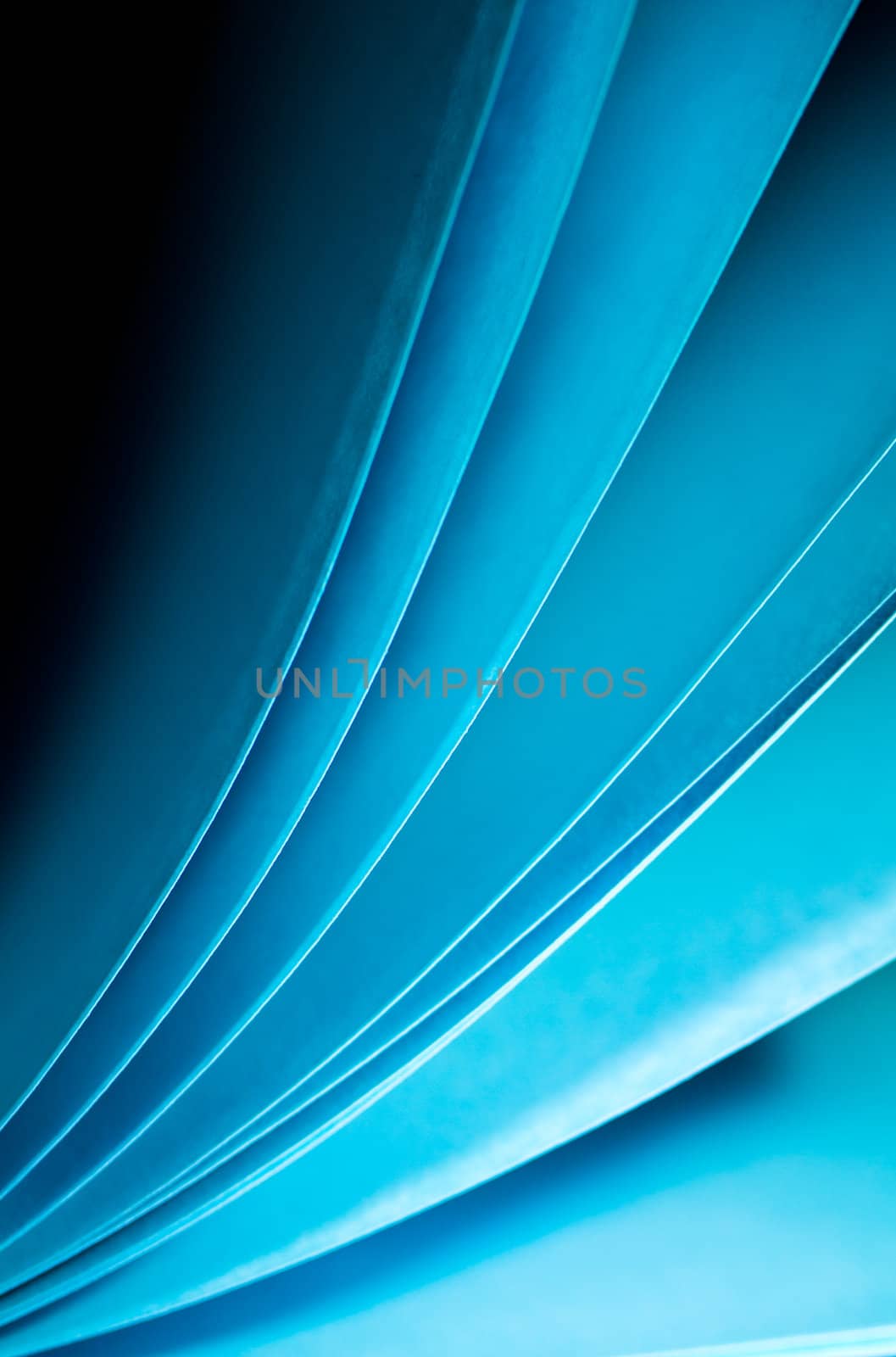 Blue notepad paper illuminated by LED viewed in portrait orientation arise from lower left angle