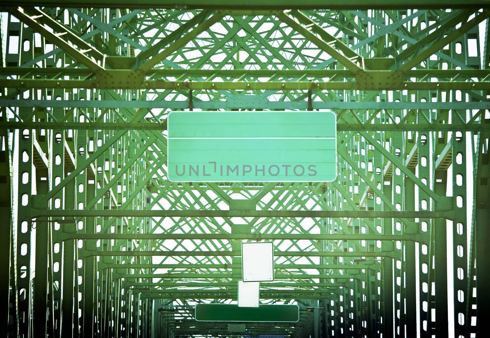 Blank Green road sign on green bridge in abstract patterns