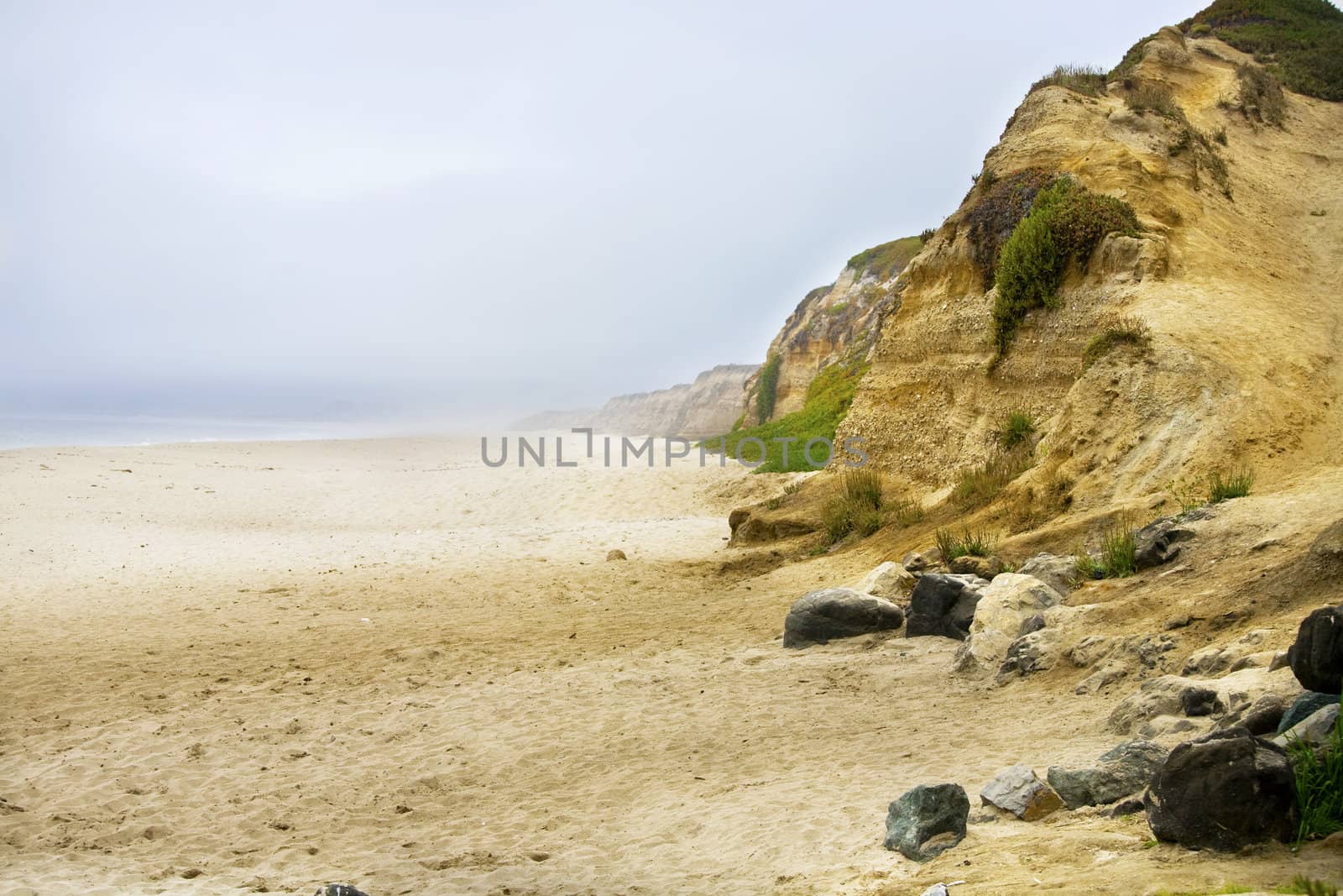 Misty sandy beach along the Pacific Ocean cliffs by jarenwicklund