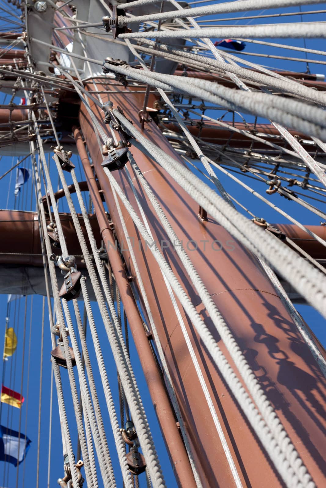 Masts and rigging of old sailing ship with flags