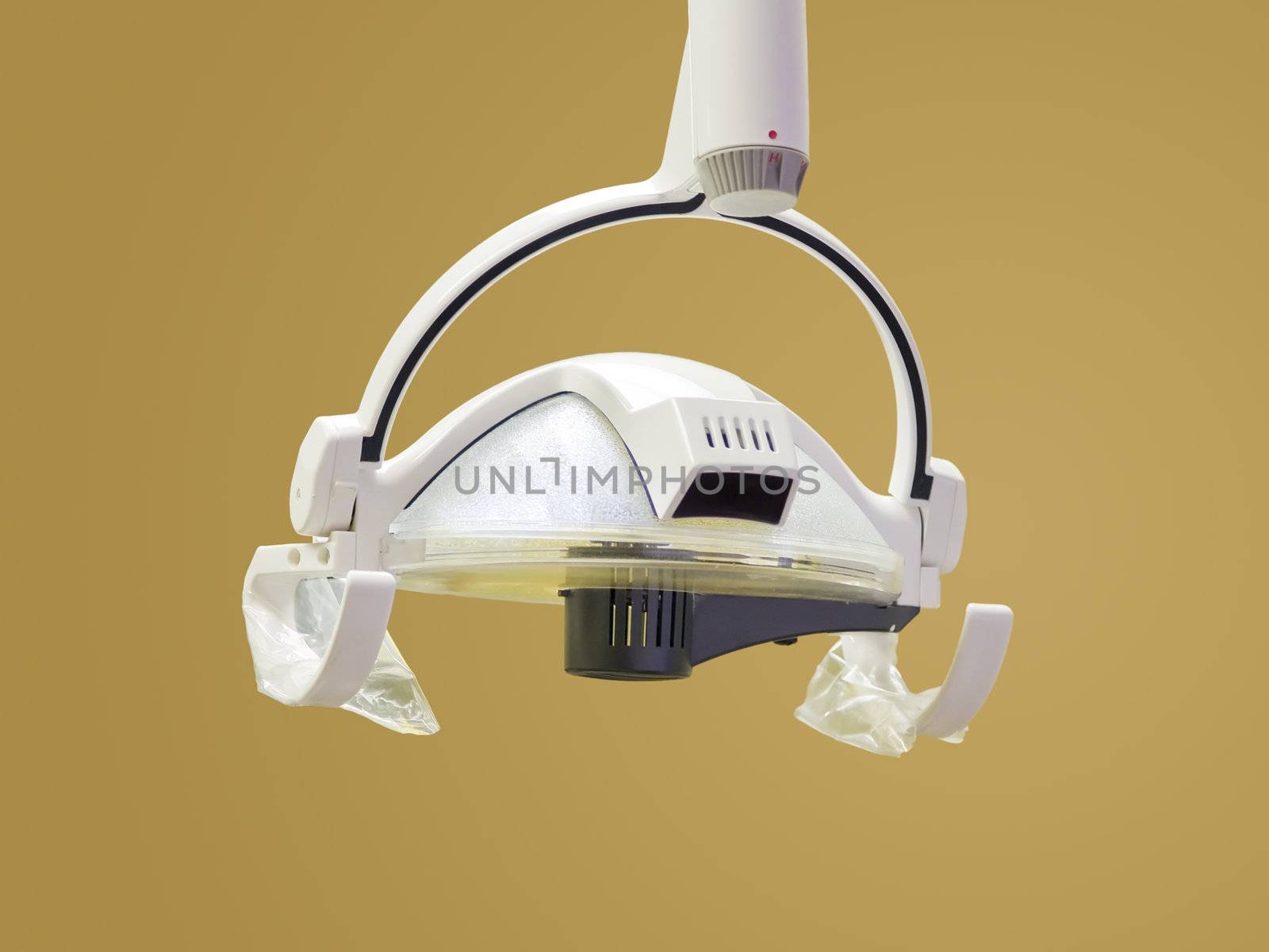 An isolation of a medical light hanging from the ceiling in a dentist's office. Clipping path included.