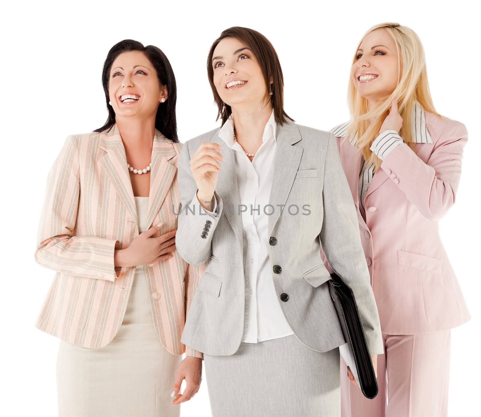 Three happy businesswomen standing on white background, looking up