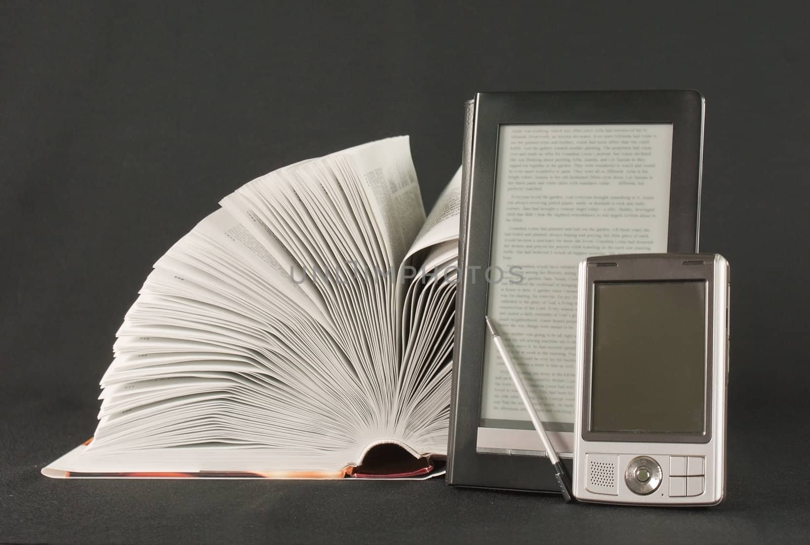 Open book, electronic book reader and hand held computer on black background by AndreyKr