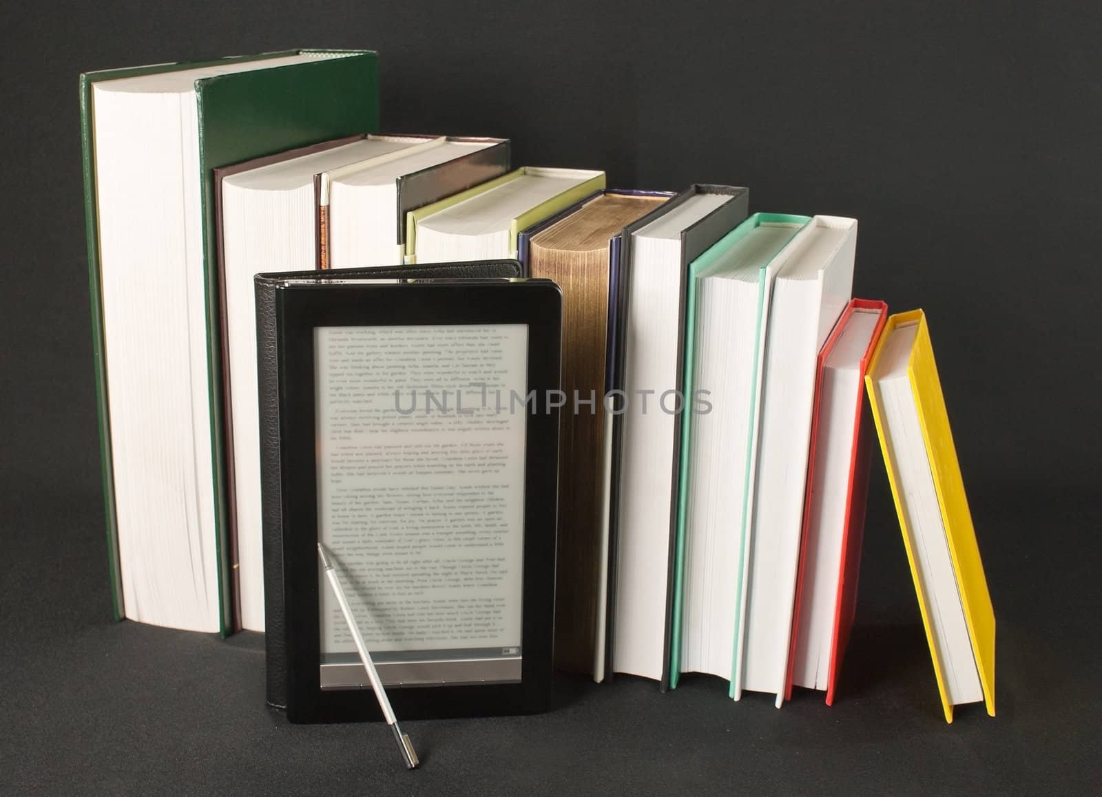 Row of printed books with electronic book reader on black background