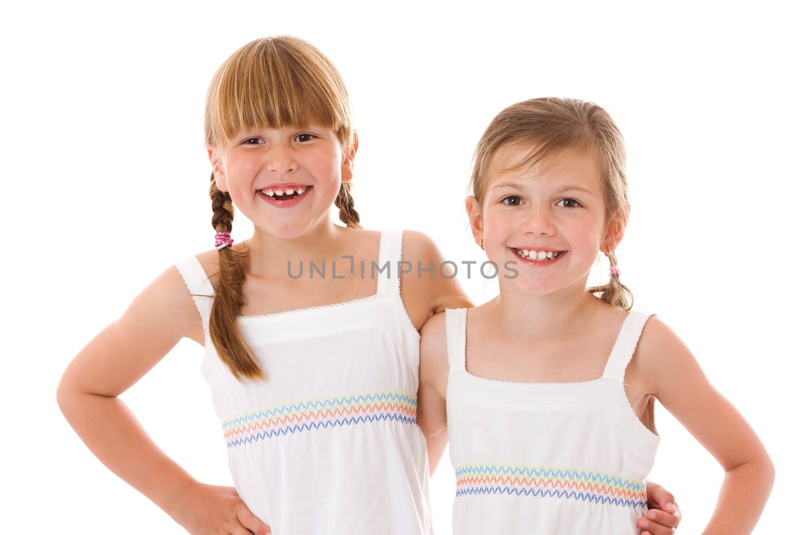 Two happy little sisters portrait isolated on white