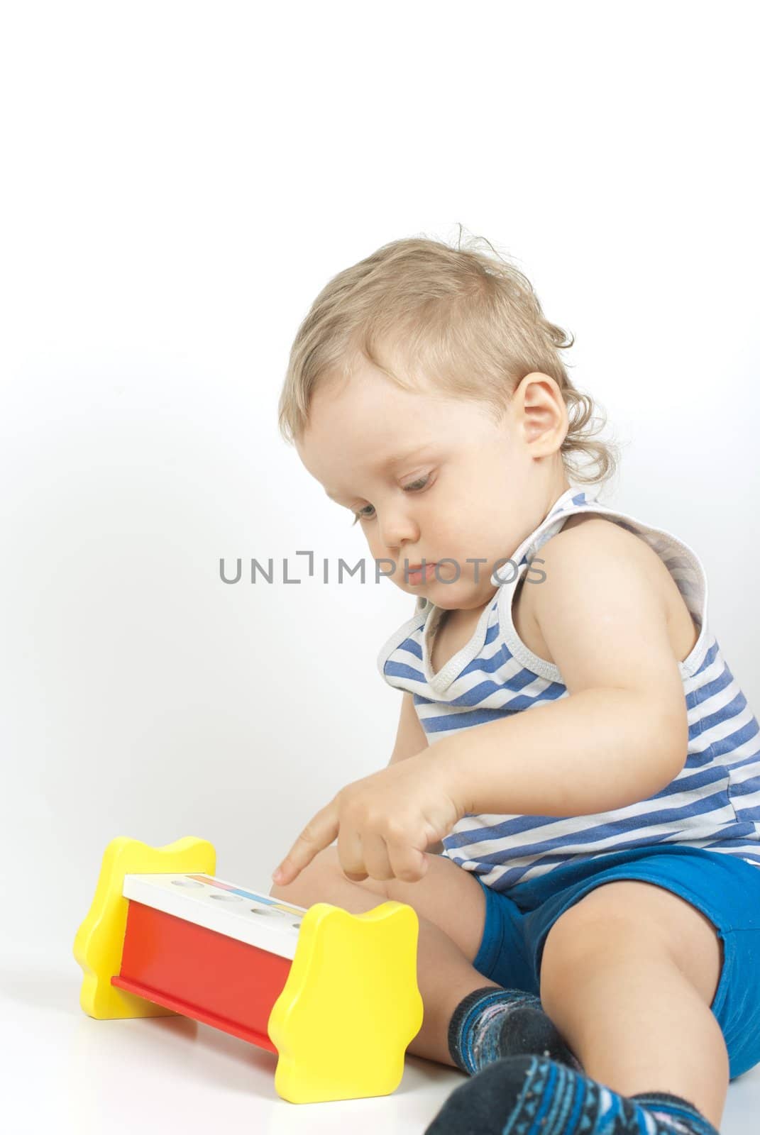 Small baby boy with a toy pyramid isolated on white