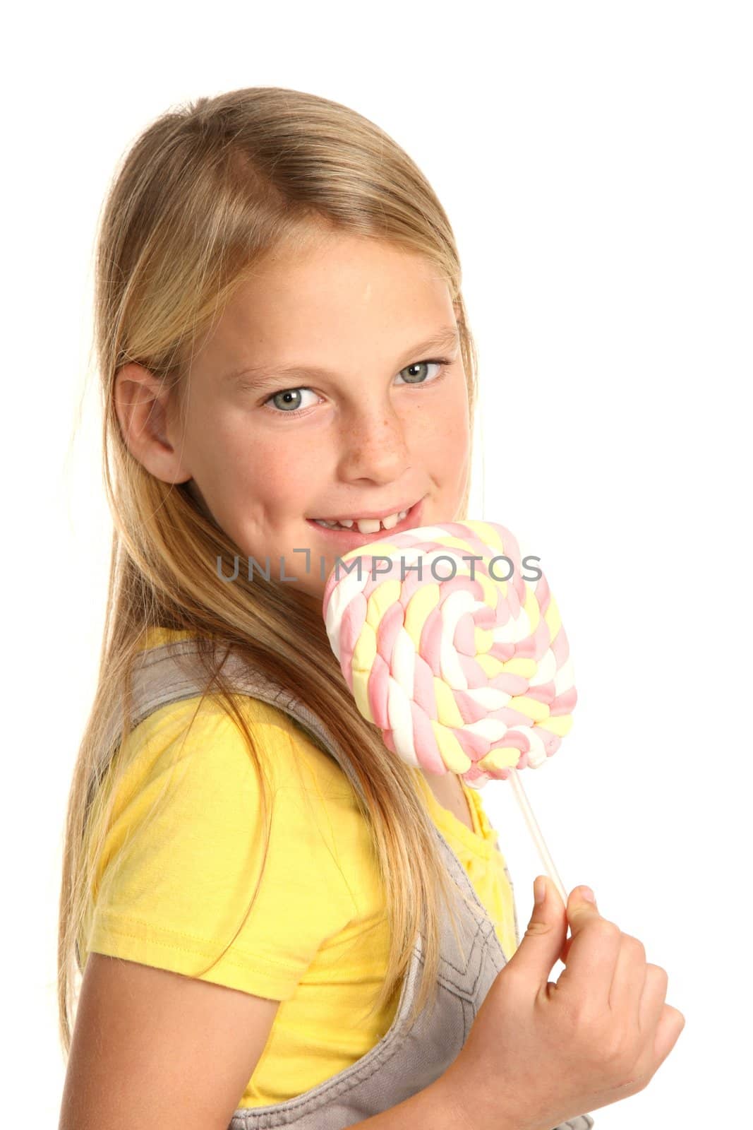 Pretty young school girl with a marshmallow candy stick