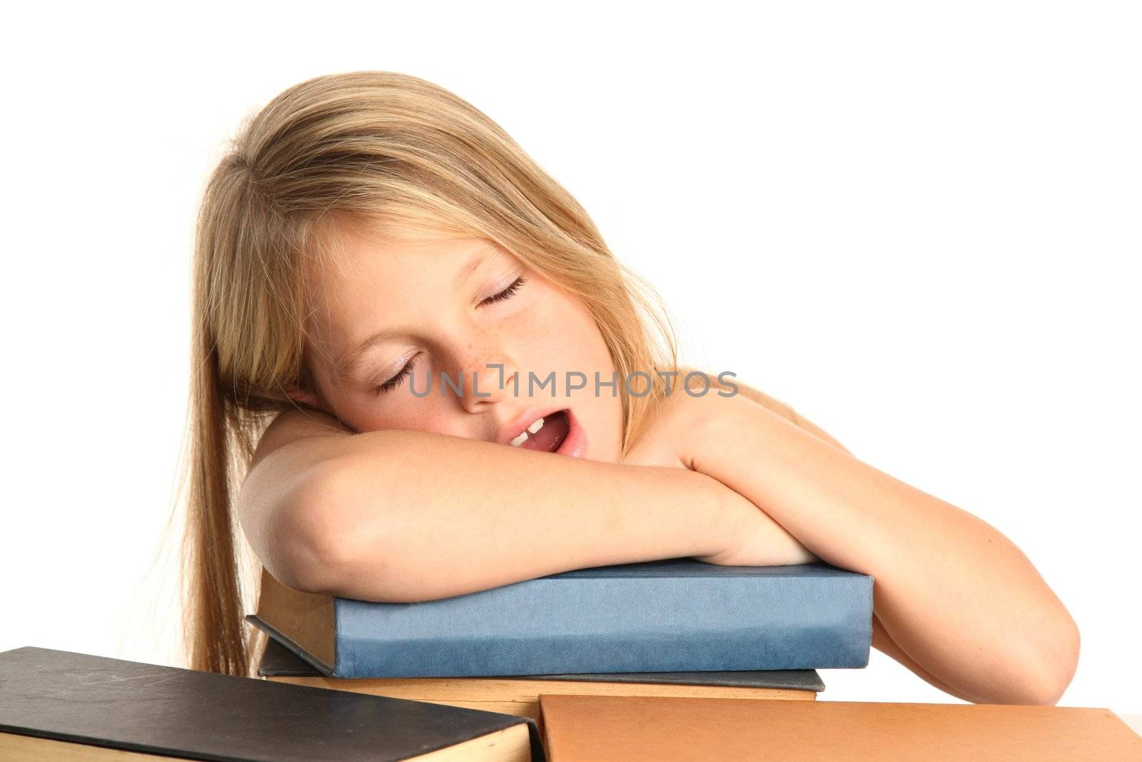 Little girl yawning and falling asleep on her books