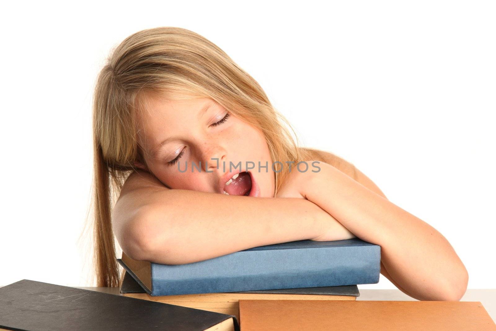 Little girl yawning while resting on her books