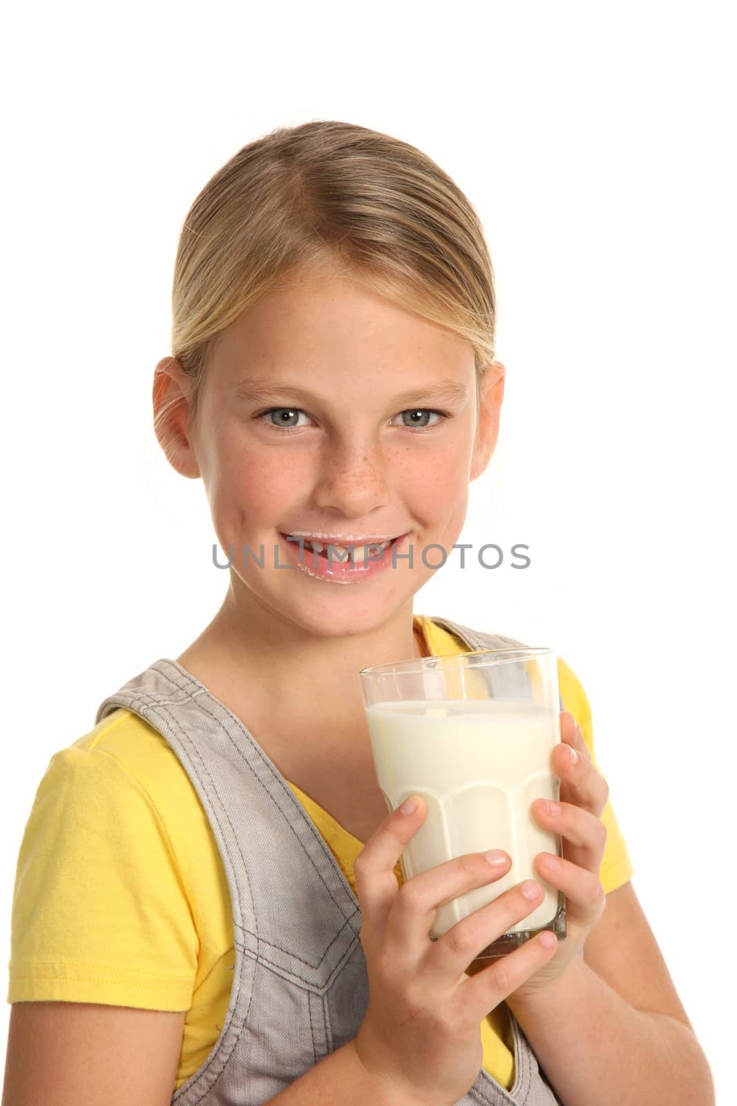 Pretty young blond girl drinking a healthy glass of milk