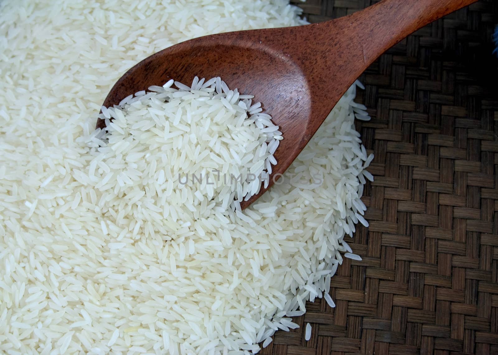 Rice on Bamboo weave and wooden spoon