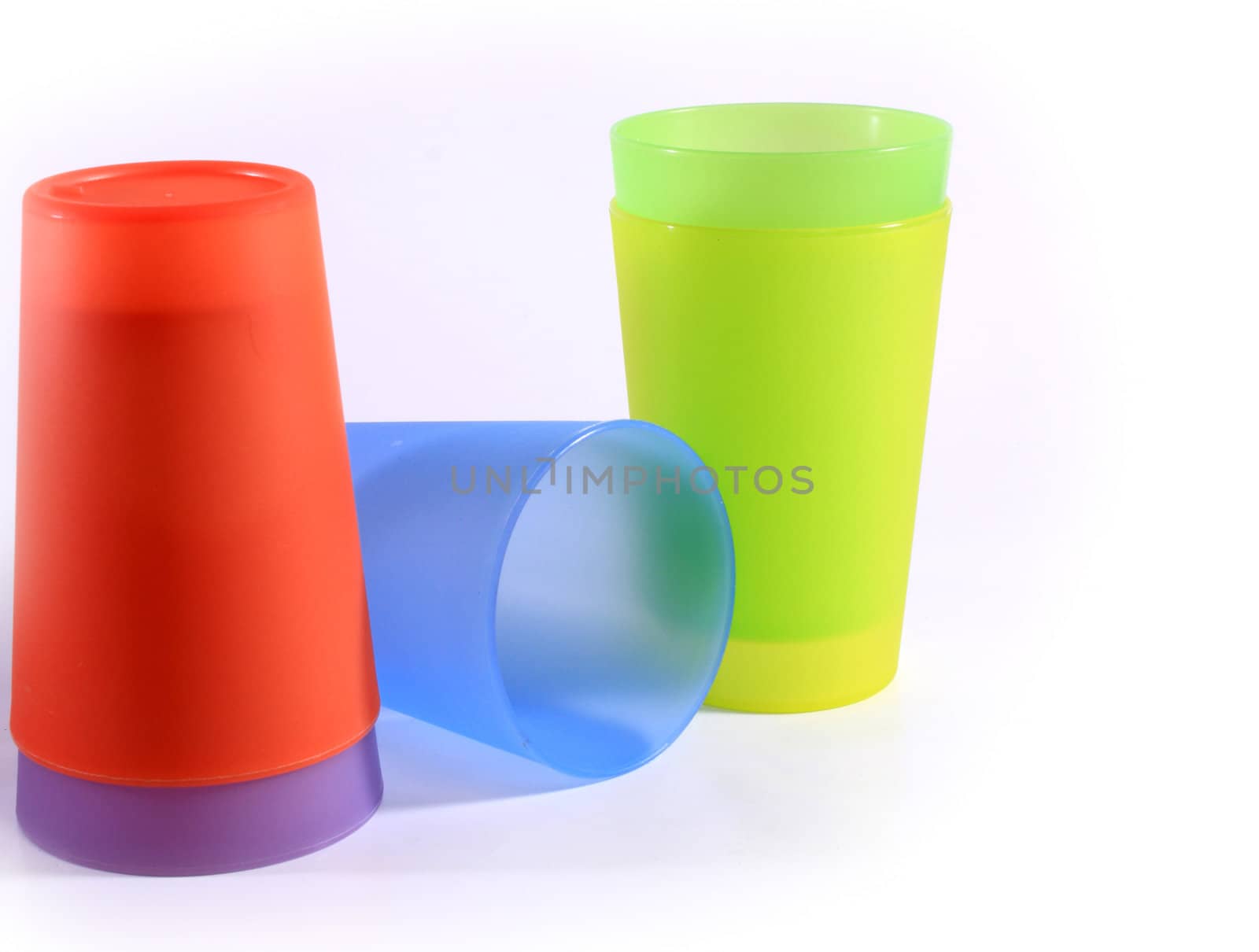 Plastic glass of various color on white background