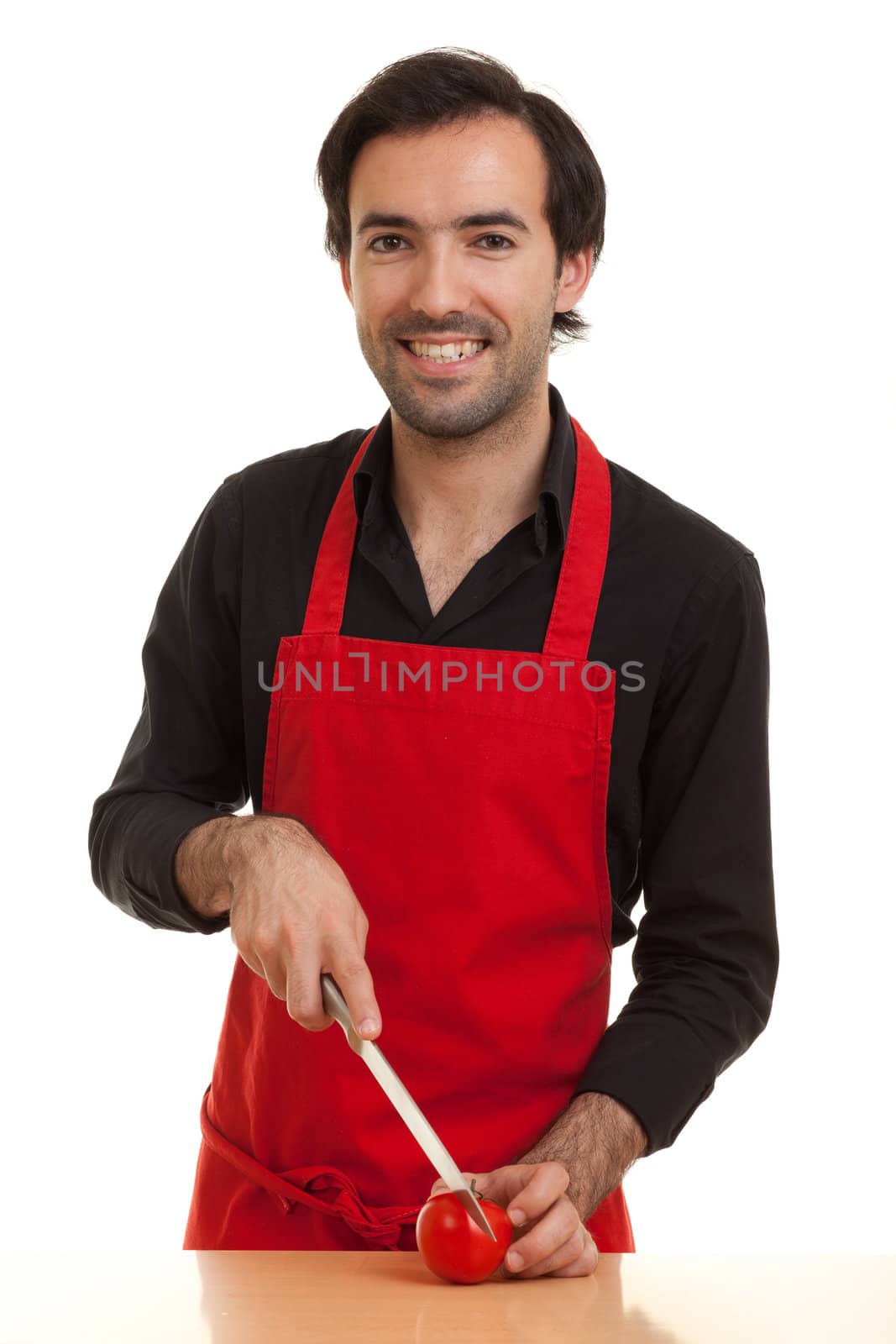 a chef cutting a tomatoe with a knife