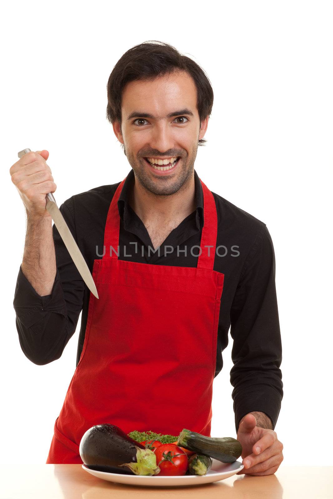 a crazy looking chef with a knife and a plate of vegetables