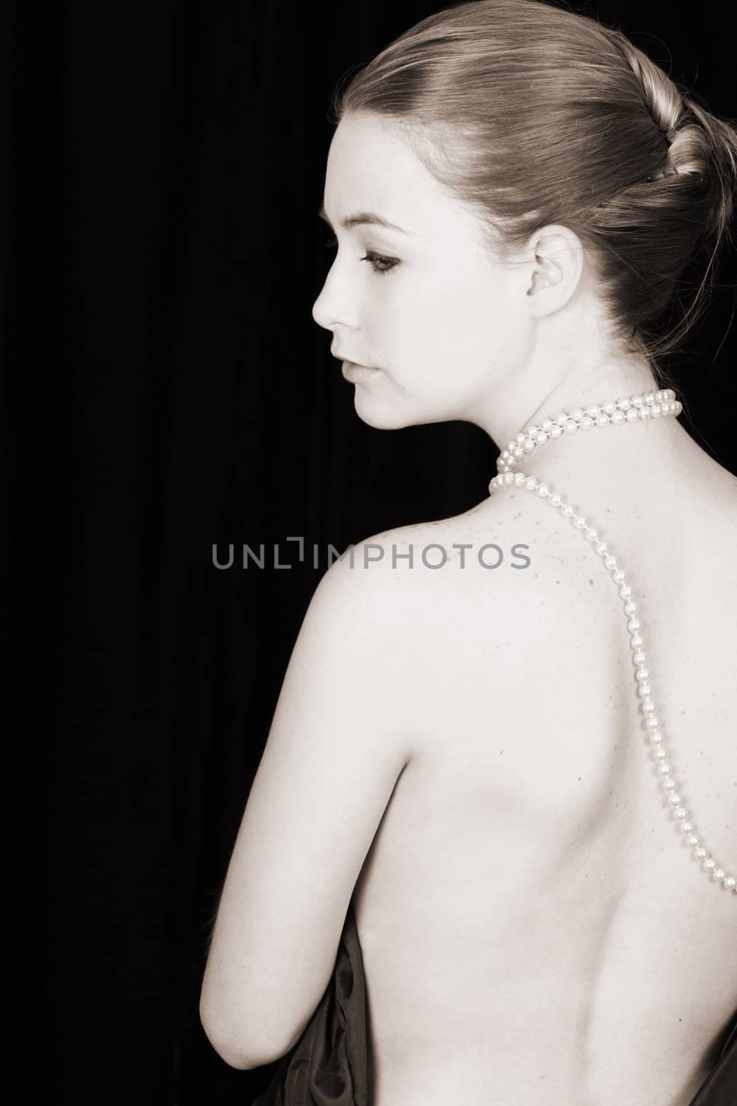 Beautiful female wrapped in fabric, wearing pearls