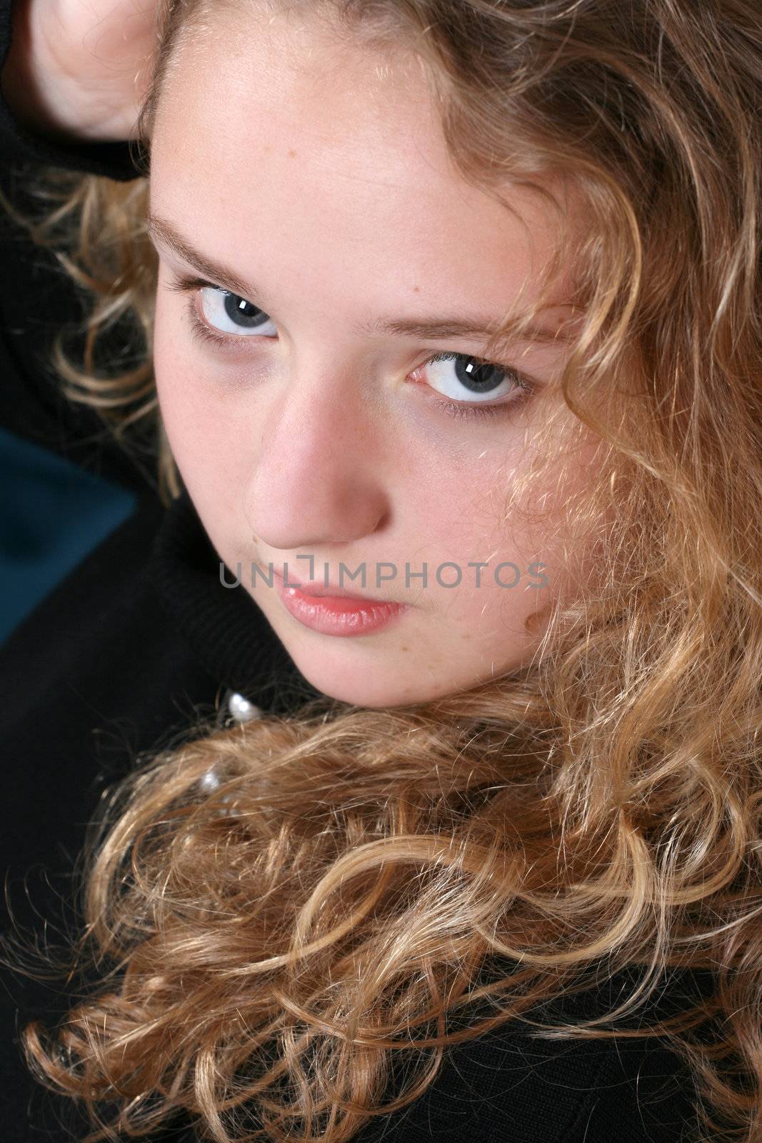 Beautiful teen with curly hair against a brick wall background