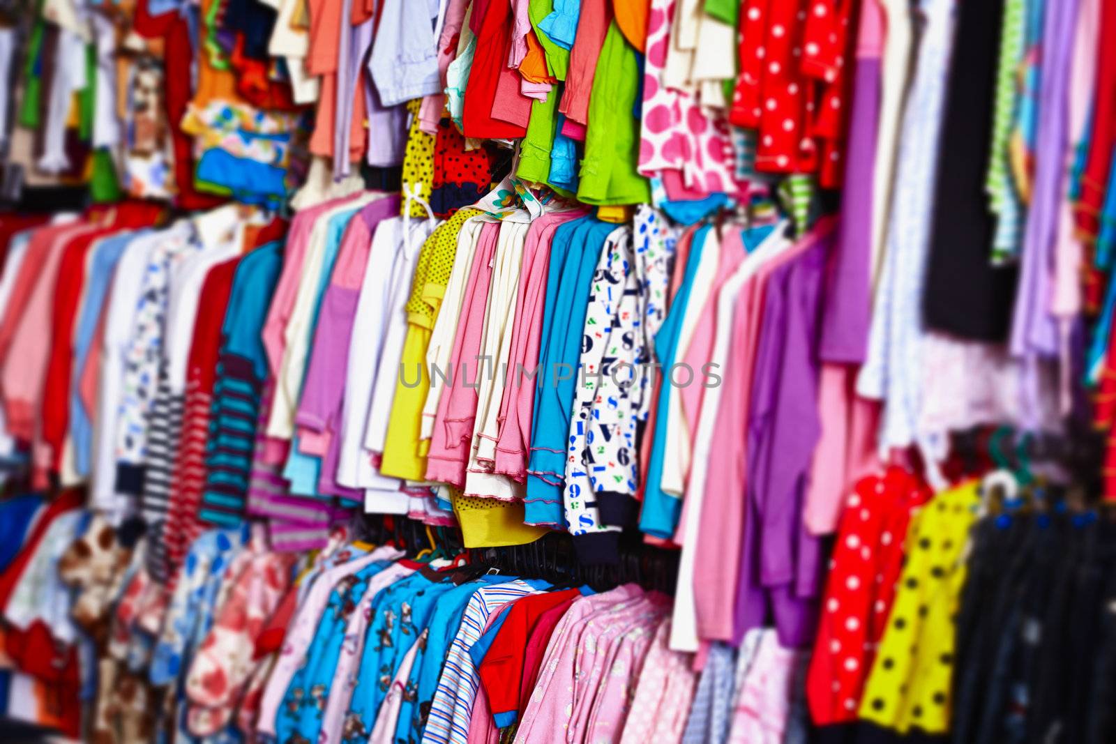 Colorful baby clothes hanging on hangers in a store