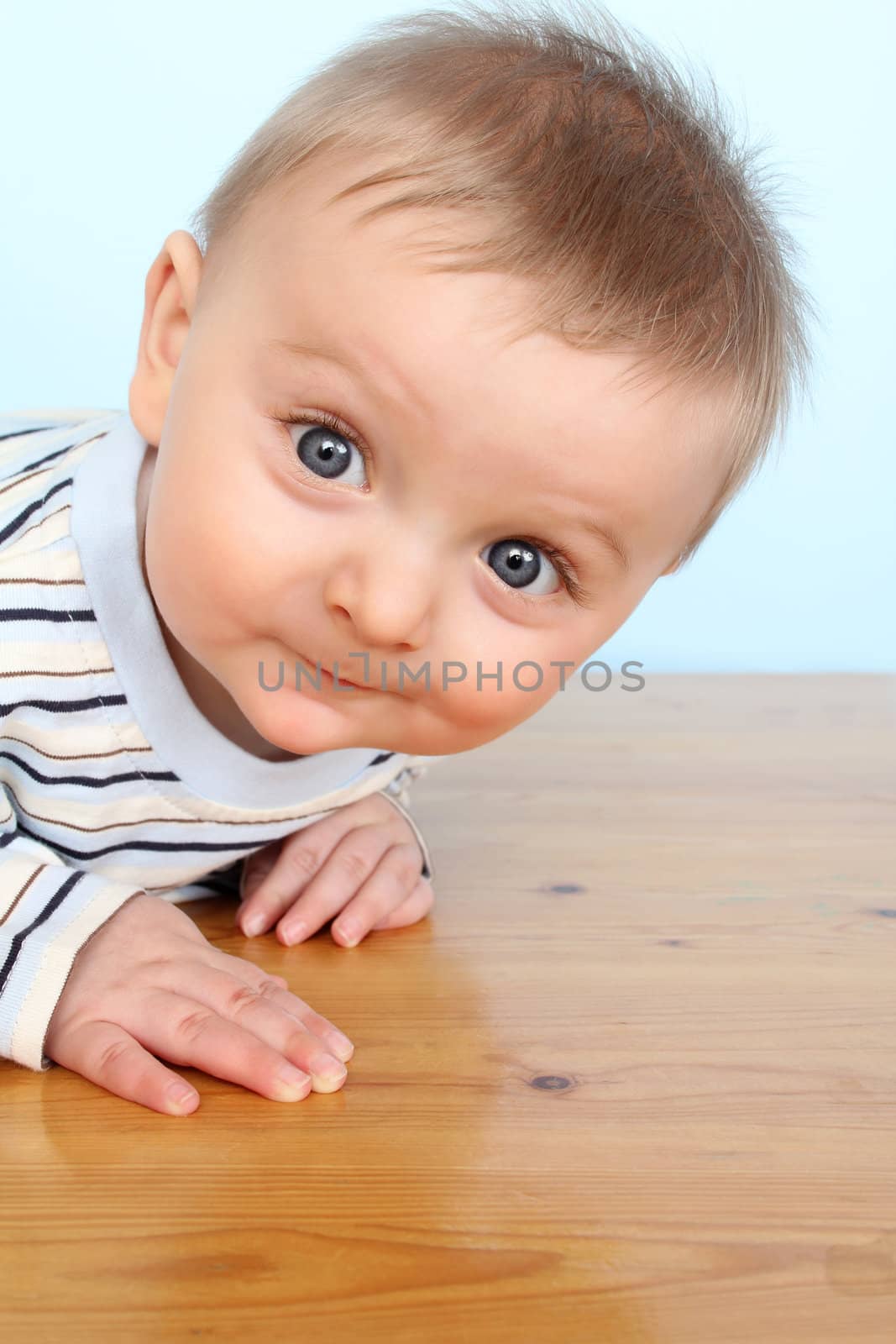 Beautiful 6 month old baby boy against blue background