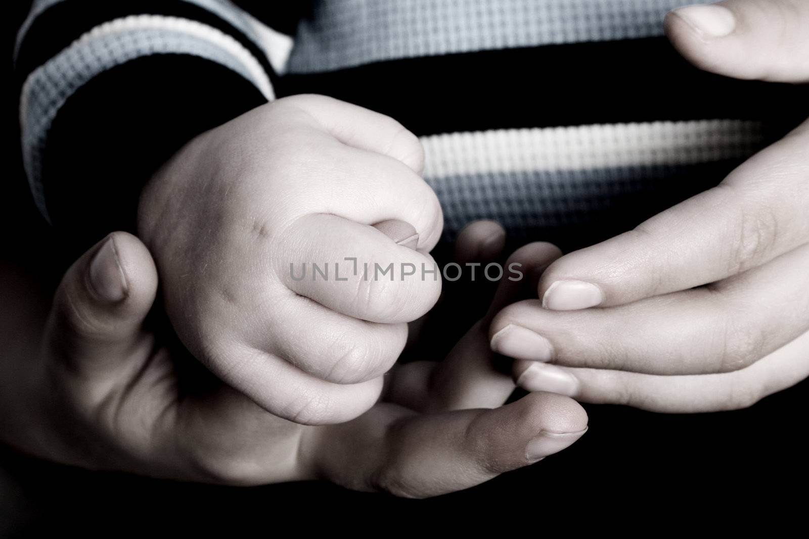 Young boy holding his baby brothers hands