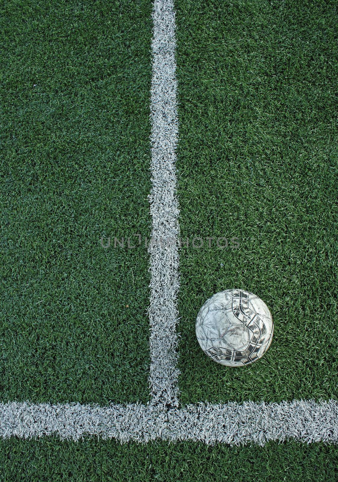 Artificial grass soccer field and old football