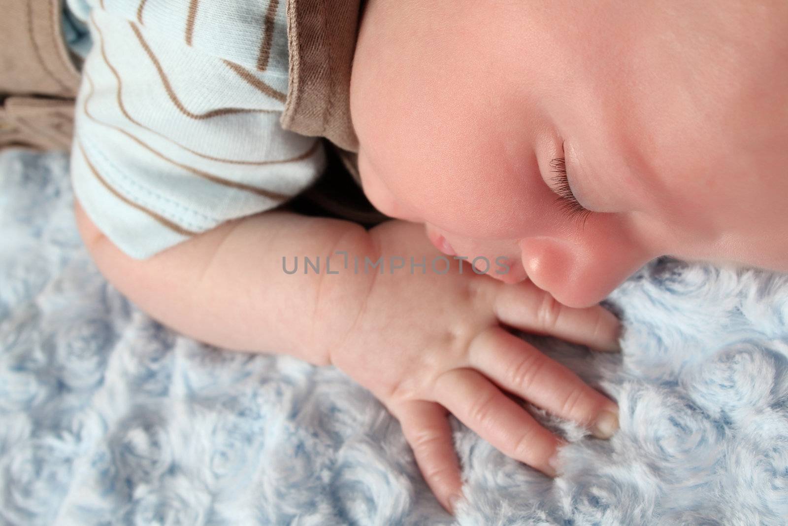 Beautiful newborn baby boy sleeping on a soft blanket