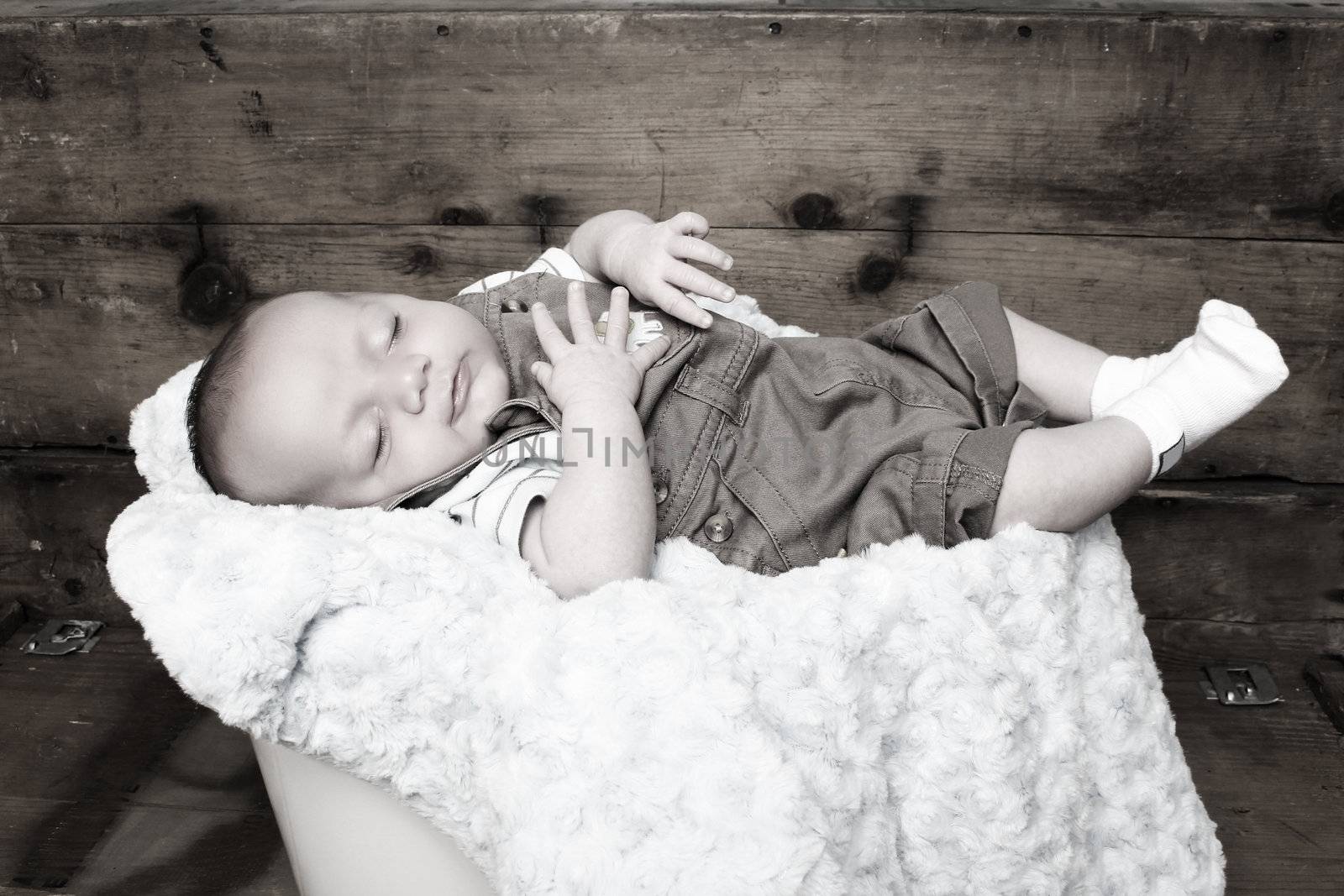 Beautiful newborn baby boy sleeping on a soft blanket