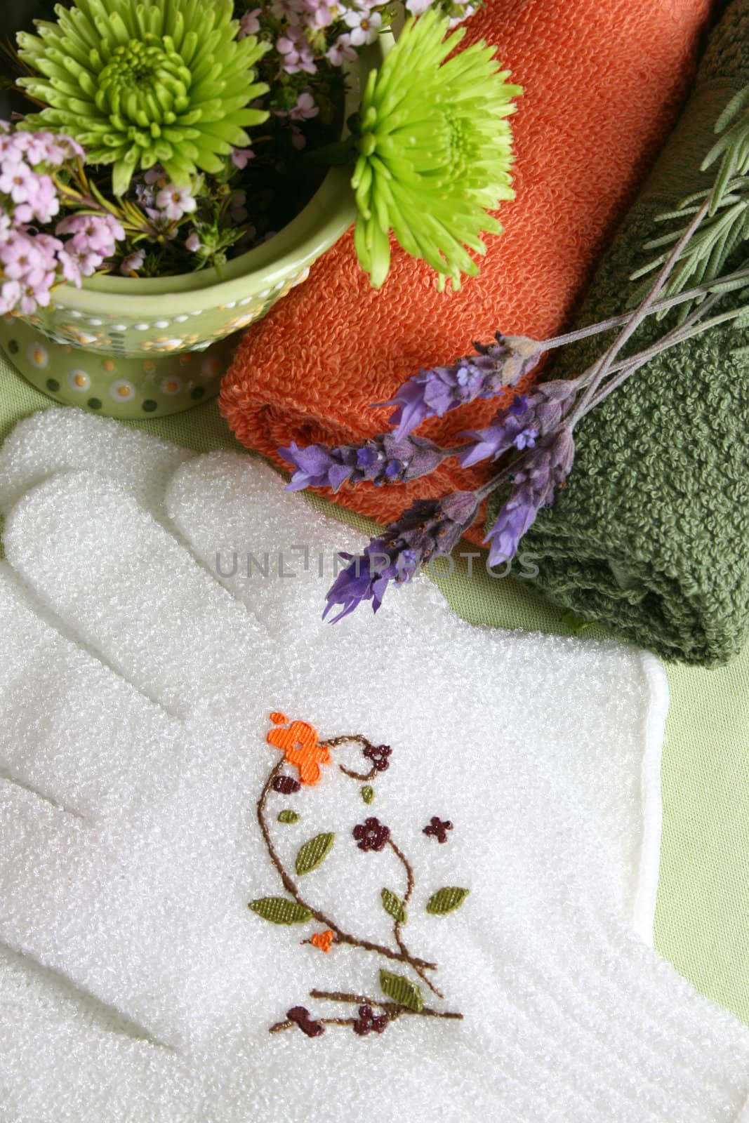 Spa Accessories setting with face cloths, gloves and flowers 