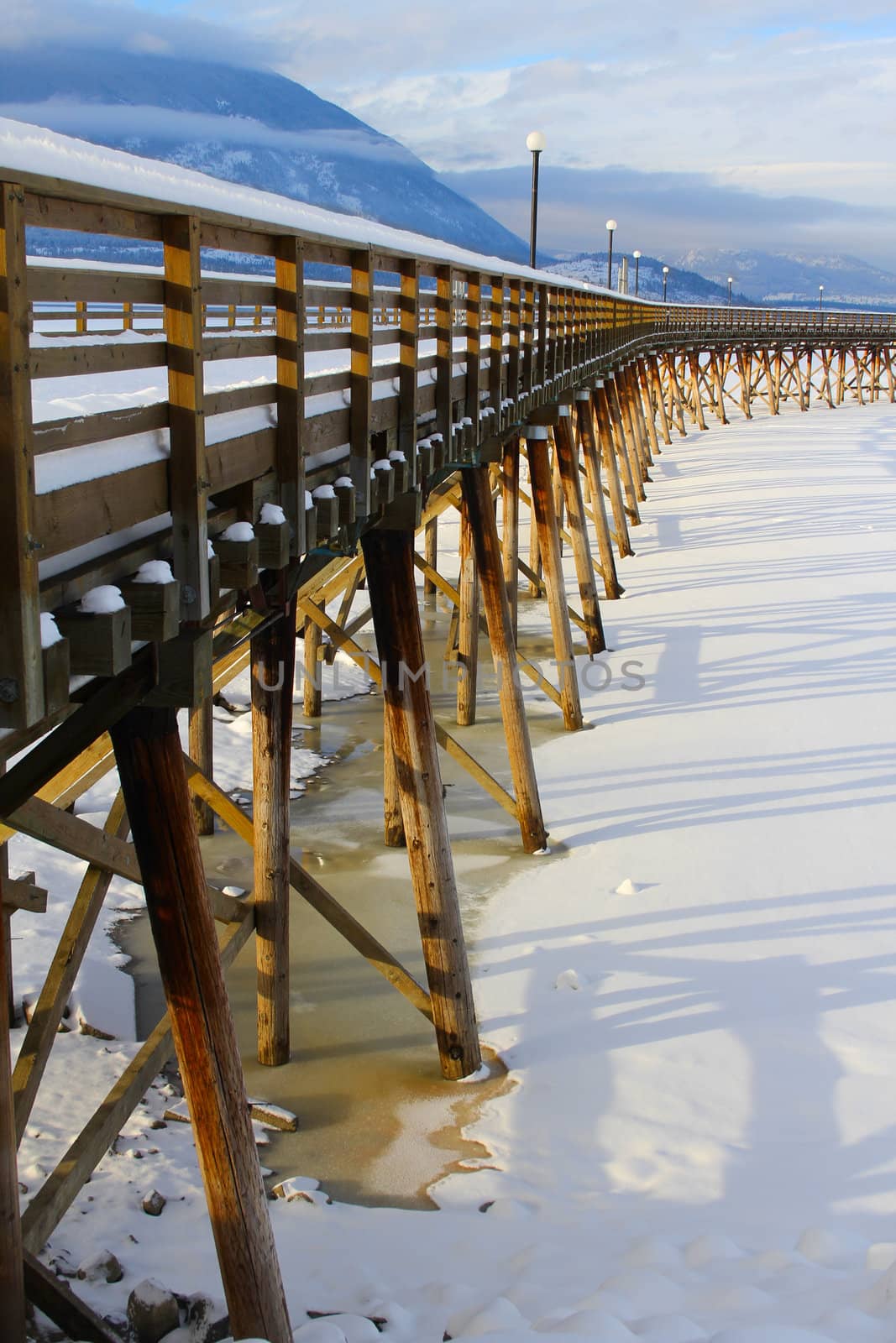 Wooden pier with snow at frozen lake in Salmon Arm 