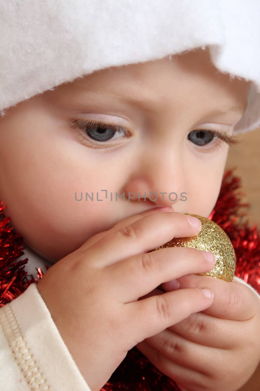 Christmas baby playing with decorations wearing a hat