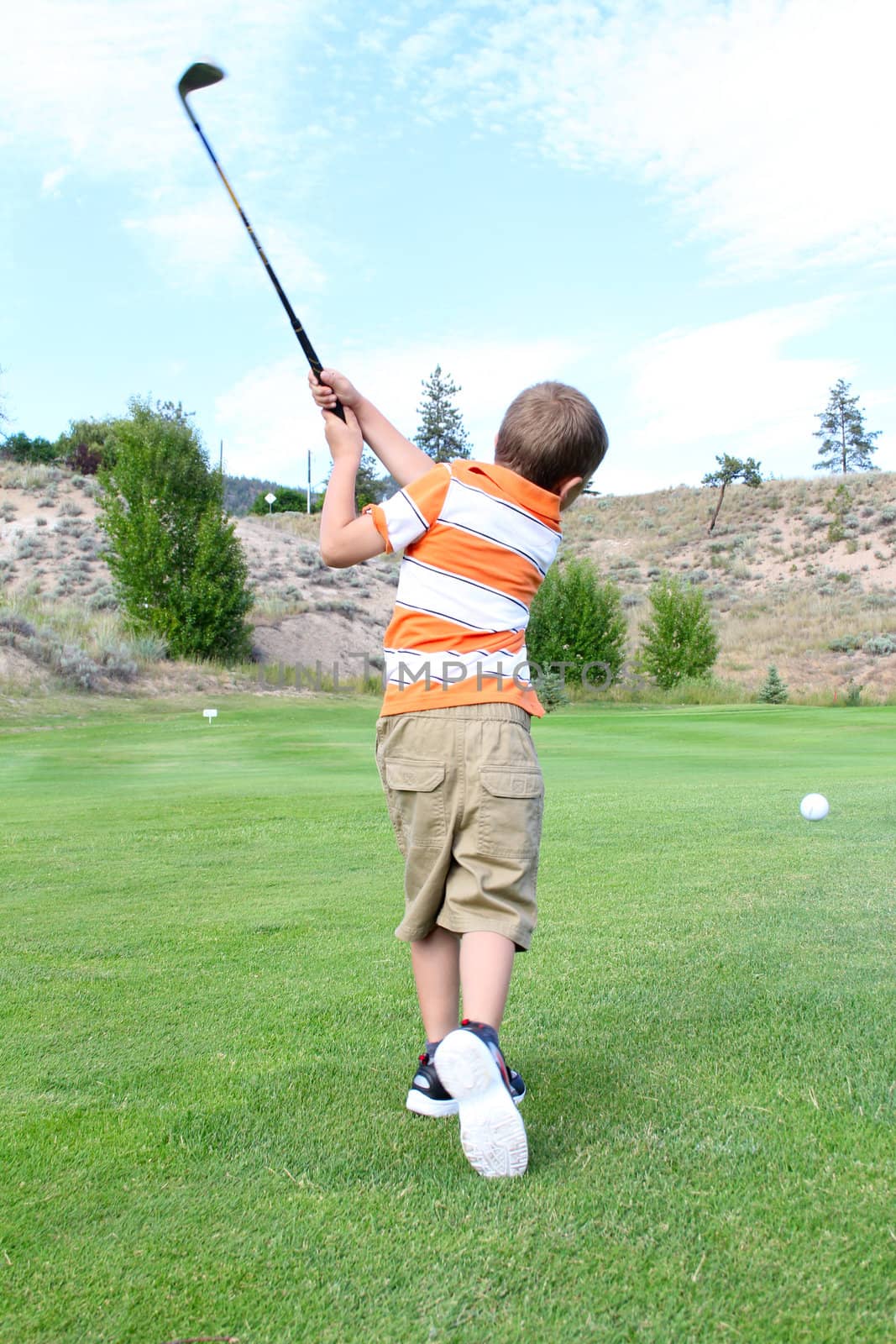 Young golfer playing a shot from the fairway