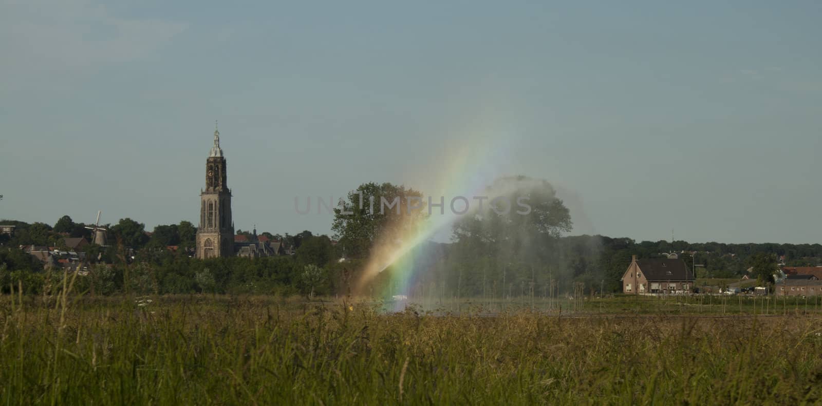 Rainbow over a field with the spray