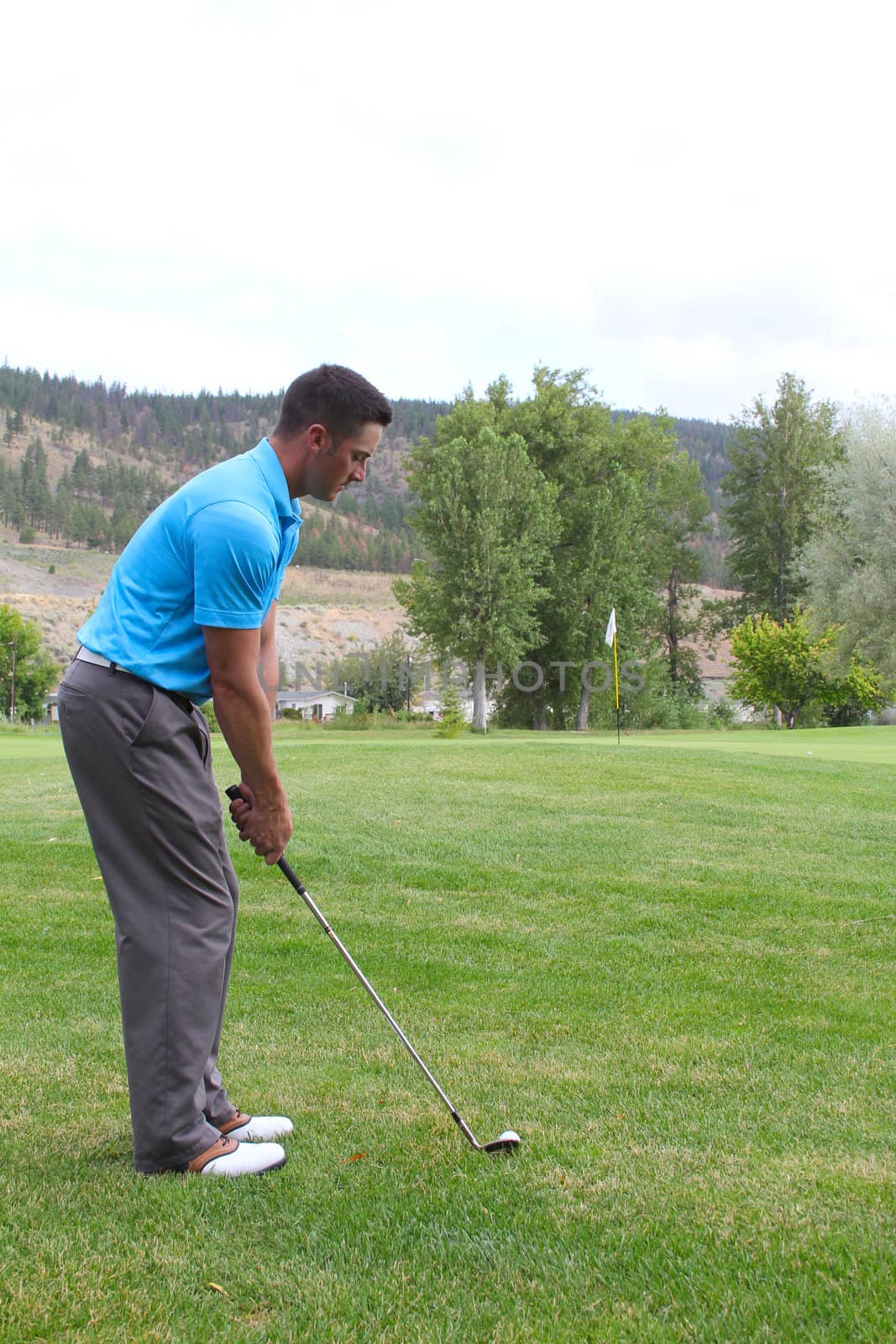 Young golfer hitting a fairway shot with an iron