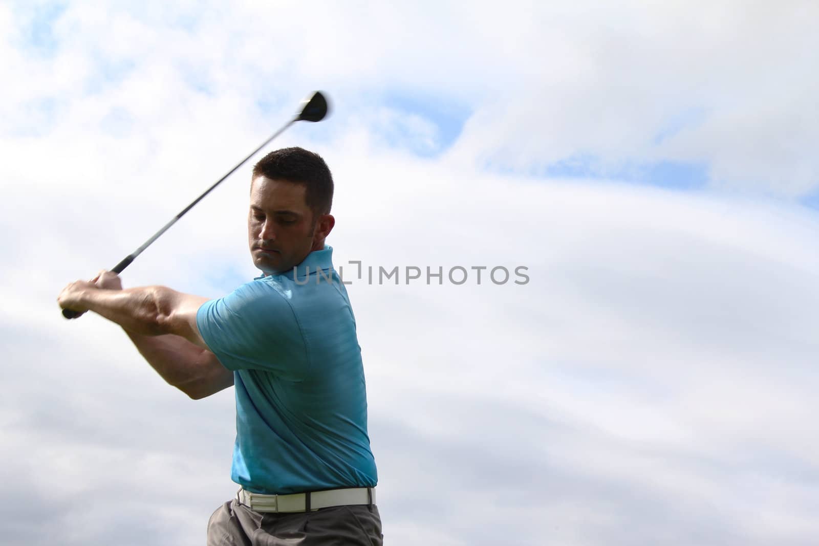 Young golfer hitting a shot with a fairway wood