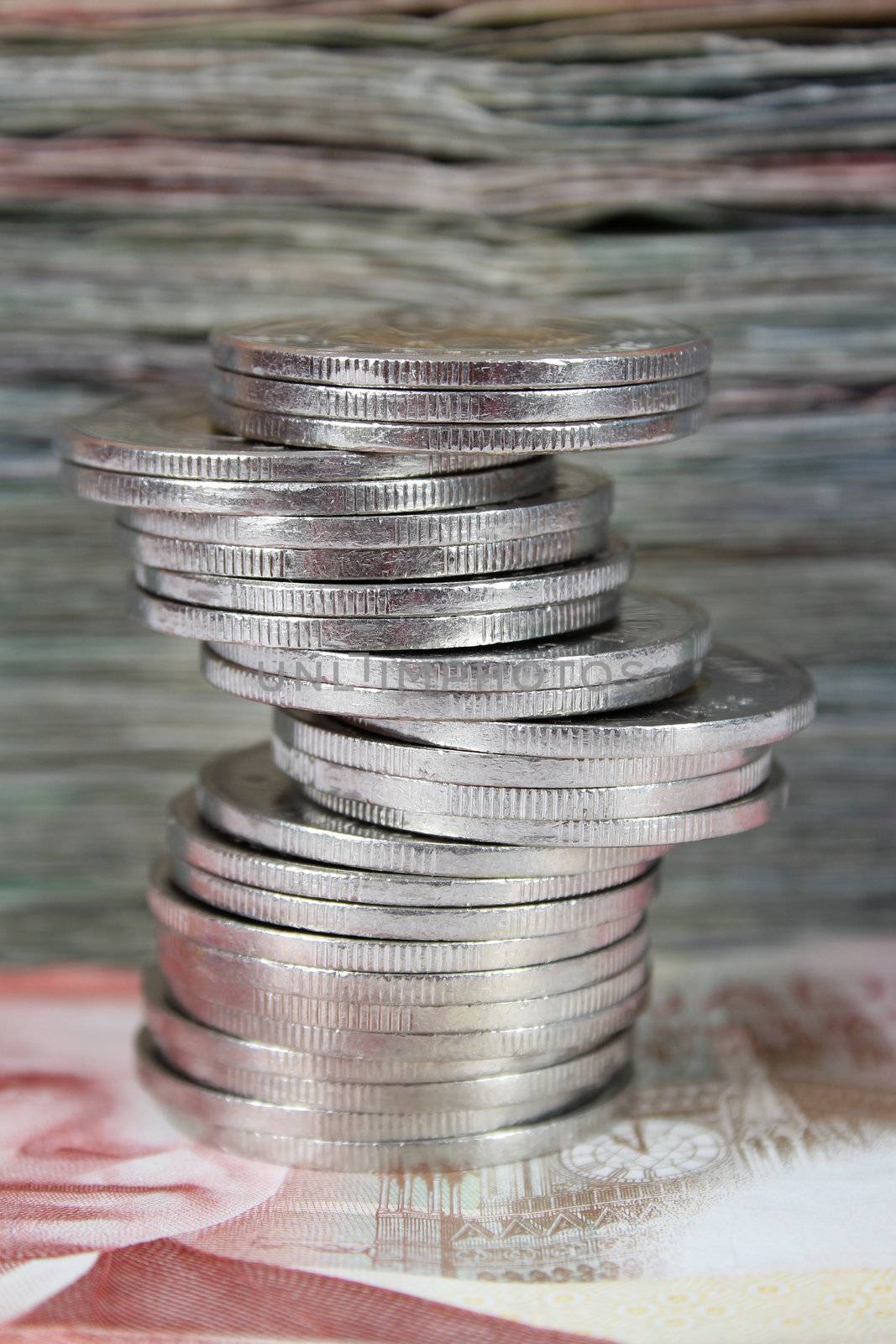 Stack of Canadian dollar bills with coins in front
