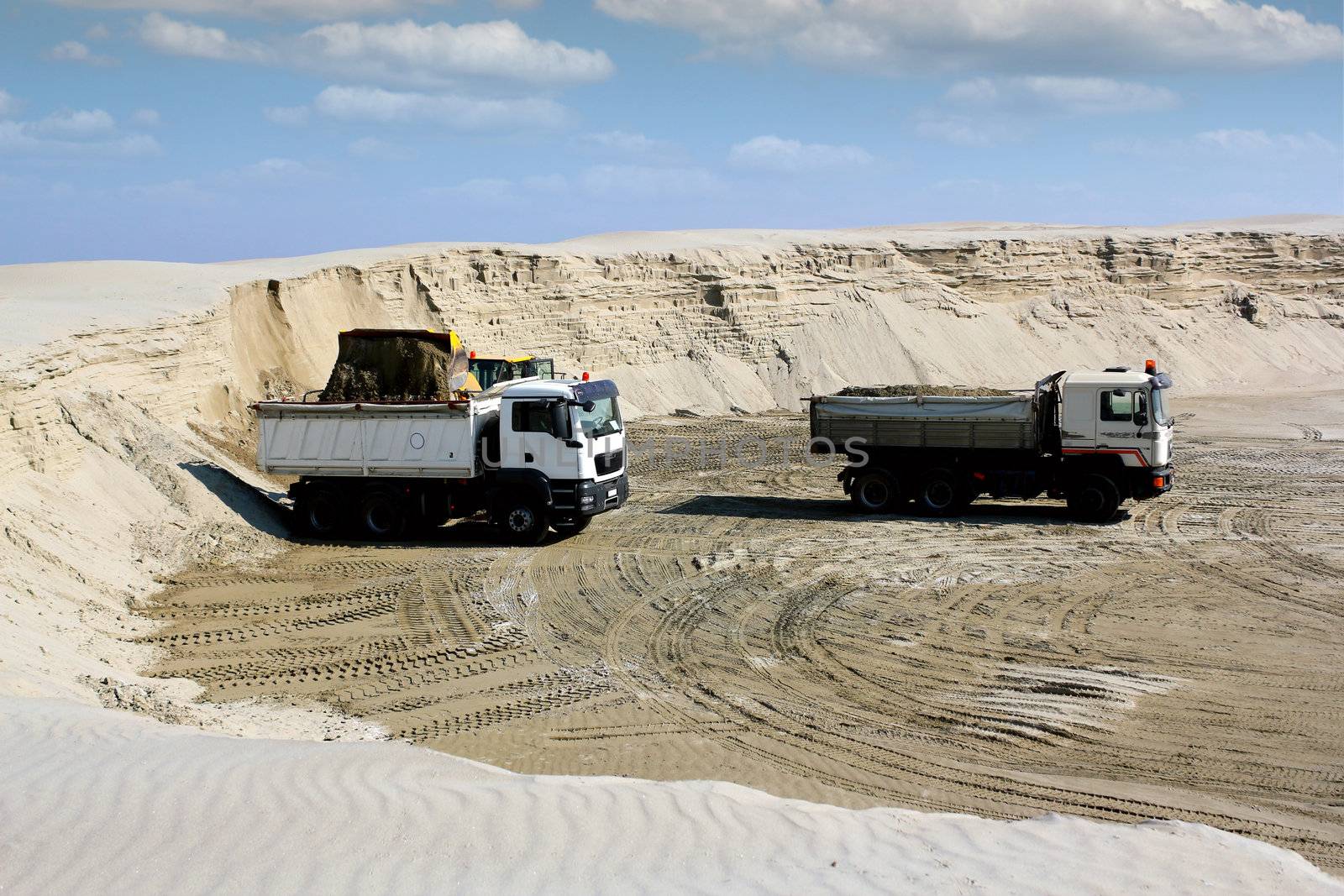 bulldozer loading truck with sand