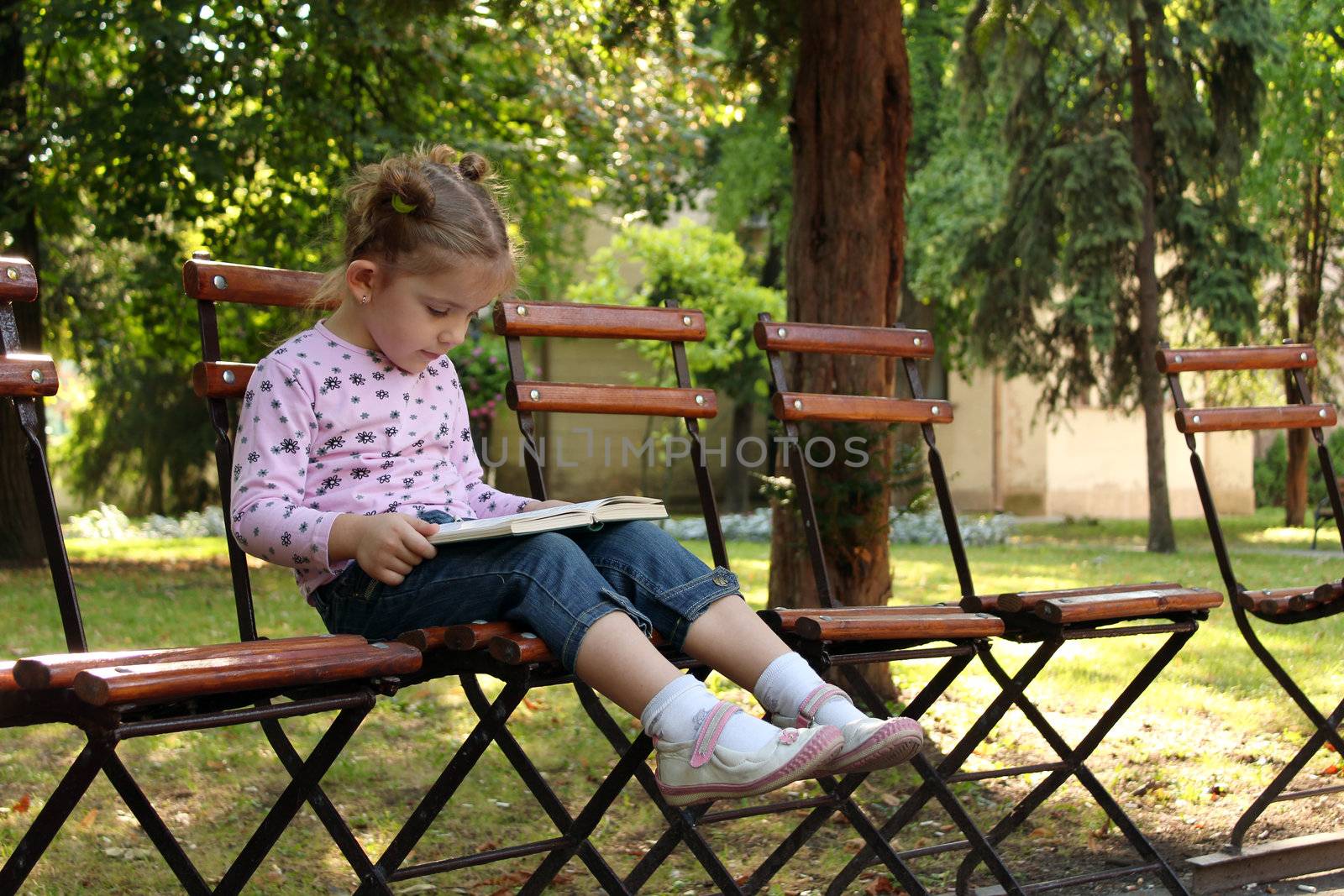 little girl reading a book by goce