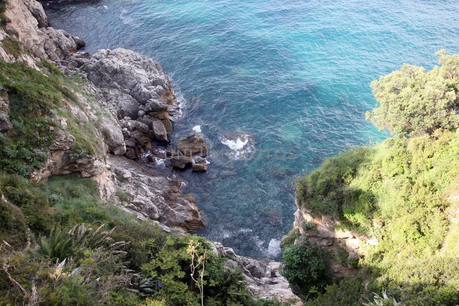 Pictorial blue Adriatic sea with rocks by atlas