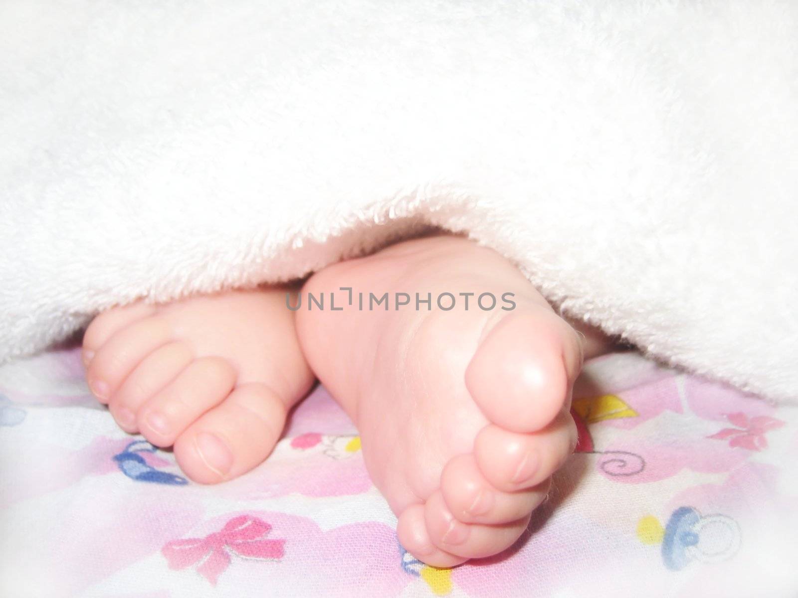 Children's legs looking out from under a white blanket